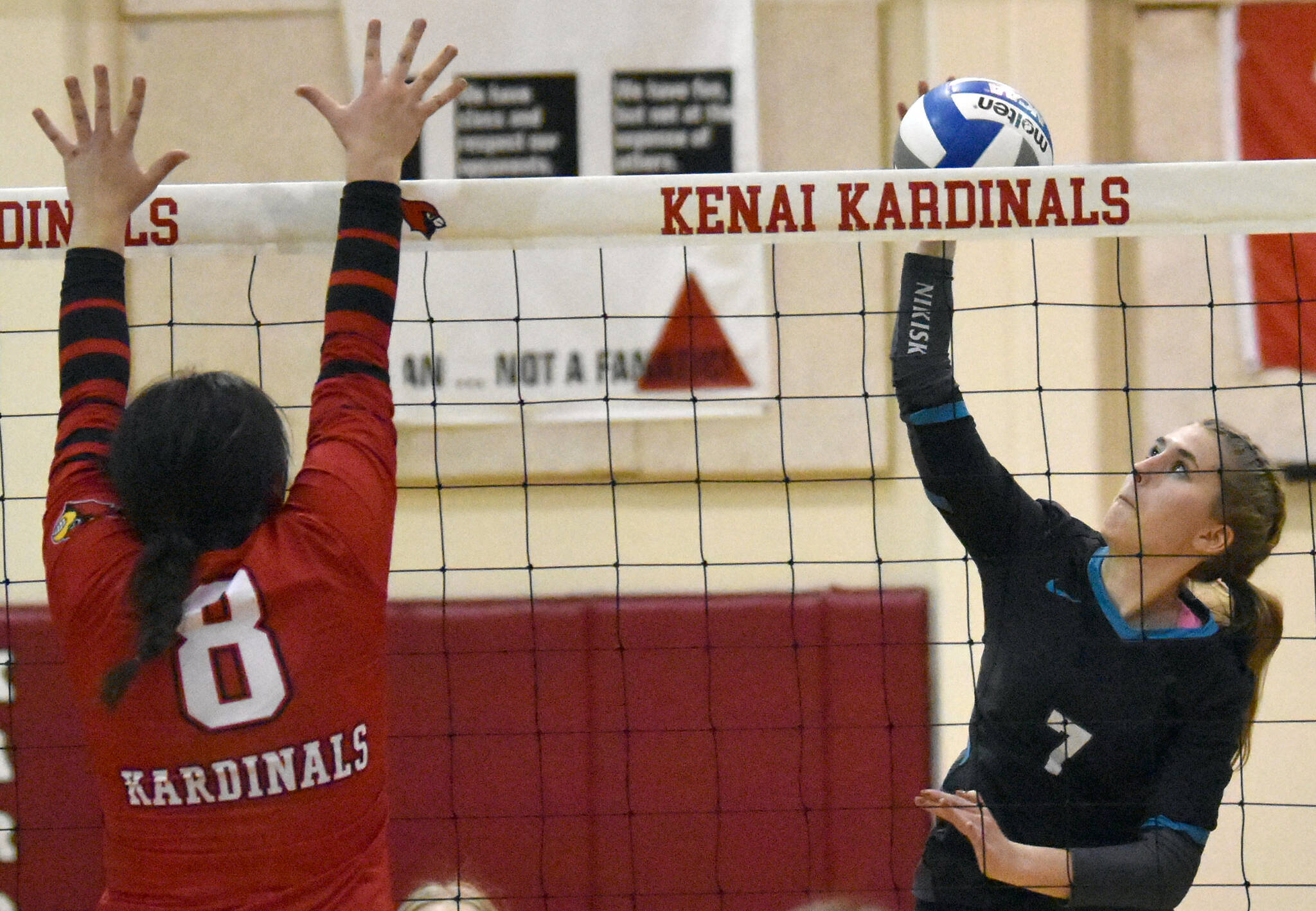 Nikiski’s Shelby Burman attacks on Kenai Central’s Jorgi Phillips on Thursday, Nov. 3, 2022, at the Southcentral Conference volleyball tournament at Kenai Central High School in Kenai, Alaska. (Photo by Jeff Helminiak/Peninsula Clarion)