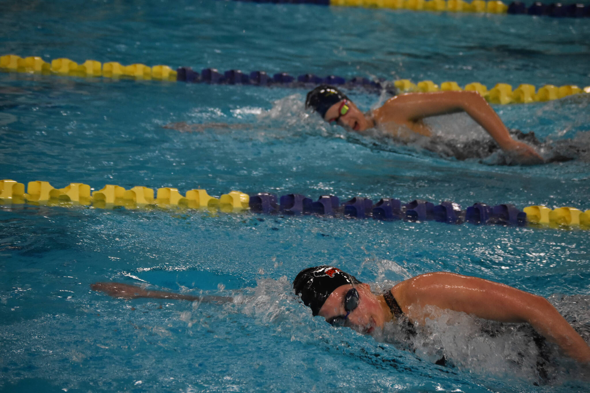 Samantha Schwarting (closest), of Juneau-Douglas, and Carly Nelson, of Homer, swim neck-and-neck in the 500-yard freestyle during finals at the ASAA State Swim & Dive Championships on Saturday, Nov. 5, 2022, at Bartlett High School in Anchorage, Alaska. (Jake Dye/Peninsula Clarion)