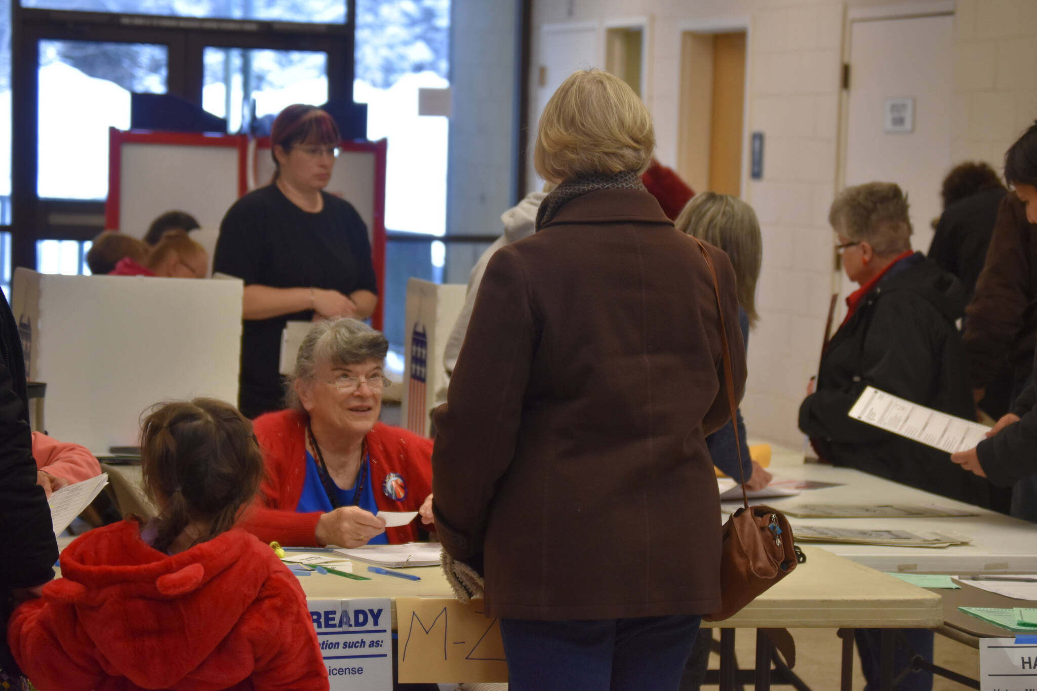 Kit Hill checks in a voter at the Kenai Mall, voting place for Kenai’s Precinct #1 in Kenai, Alaska on Election Day, Nov. 8, 2022. (Jake Dye/Peninsula Clarion)