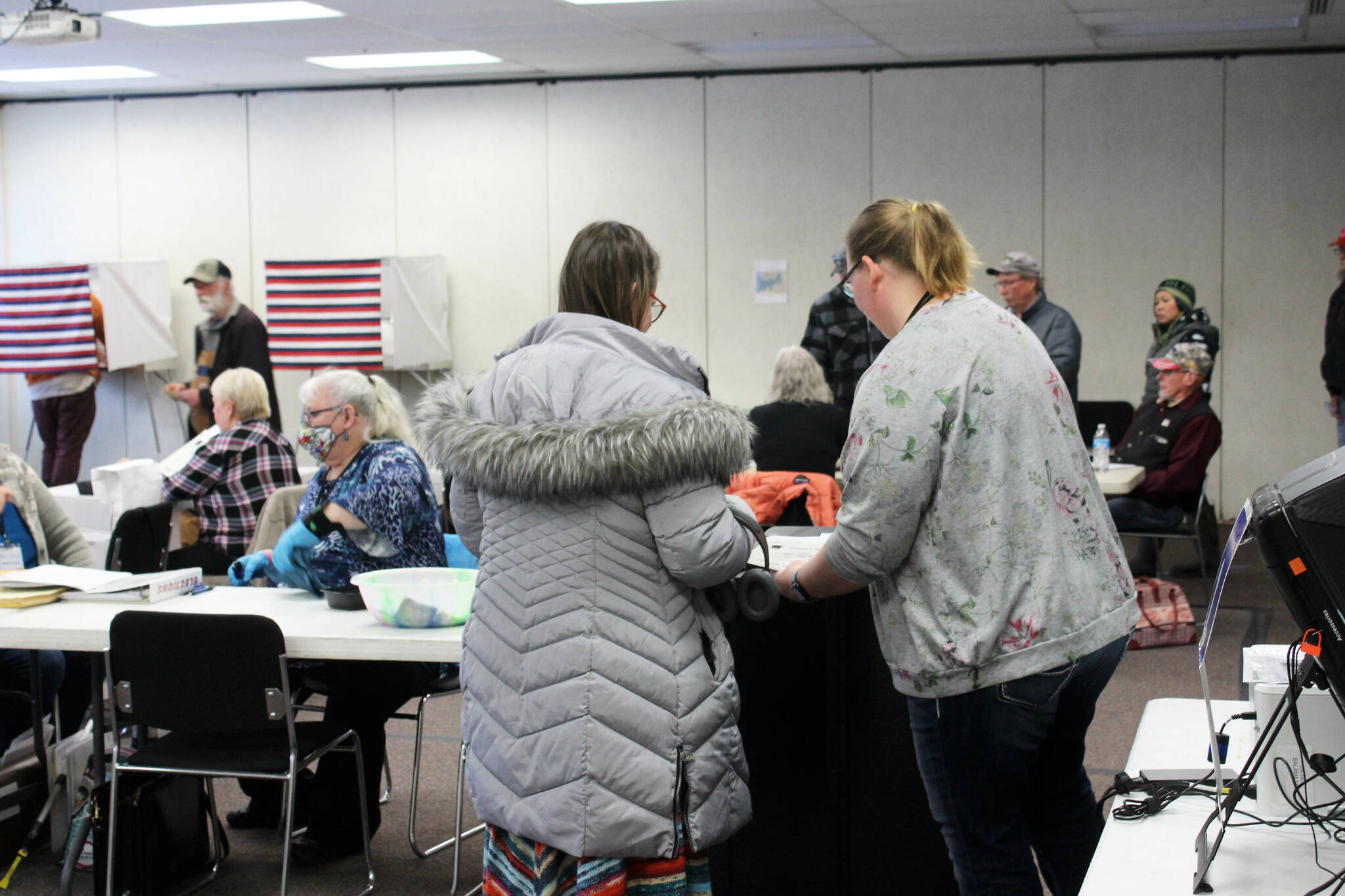 Poll worker Harmony Bolden (right) helps a voter cast their ballot at the Soldotna Regional Sports Complex on Tuesday, Nov. 8, 2022 in Soldotna, Alaska. (Ashlyn O’Hara/Peninsula Clarion)