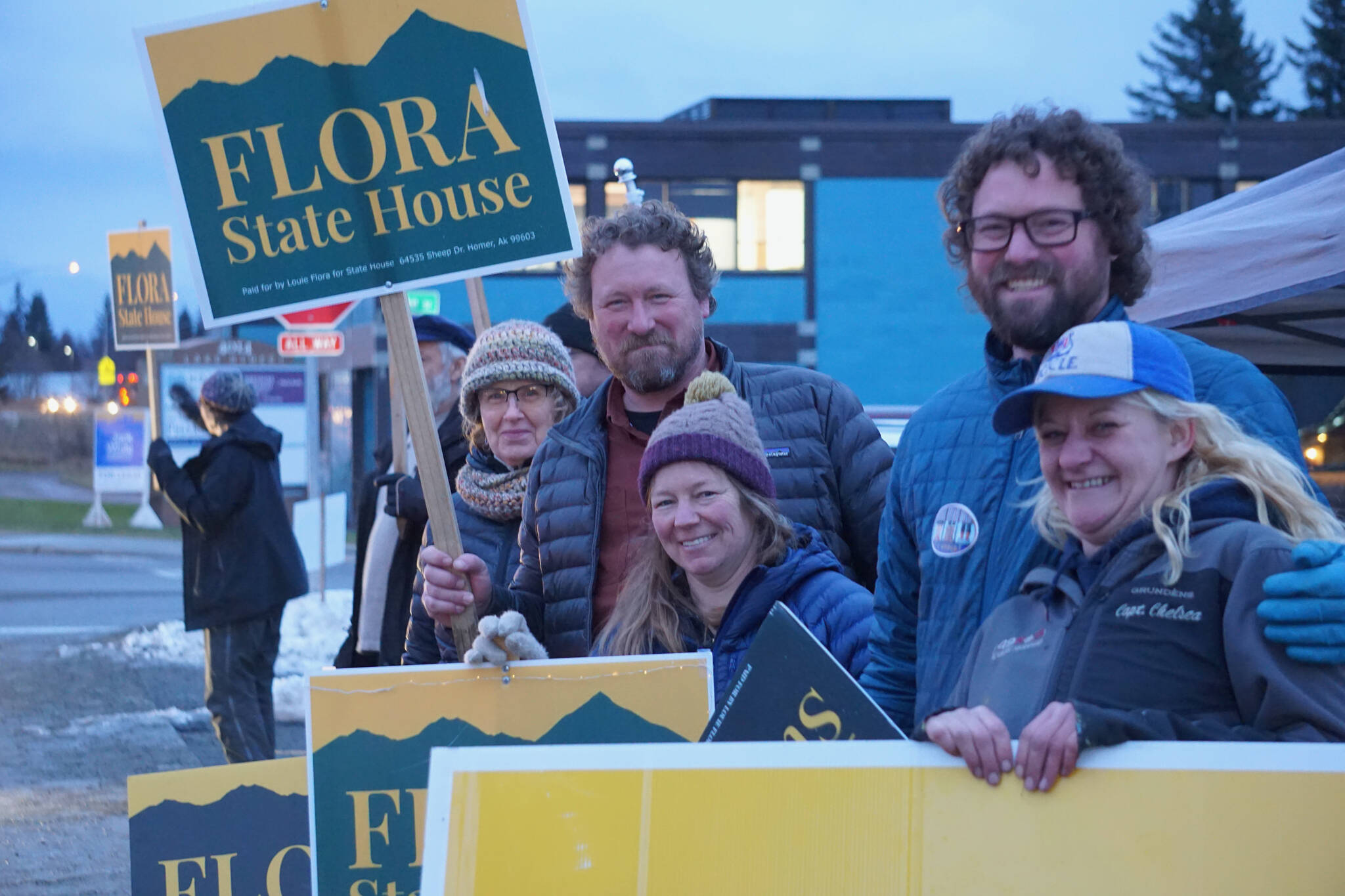 Louie Flora, center, a candidate for District 6 State House Representative, waves a sign on Tuesday, Nov. 8, 2022, on Pioneer Avenue in Homer, Alaska. Behind him is former Rep. Paul Seaton and Tina Seaton, and in front is his wife, Sarah Banks, brother Mikee Flora, and friend Chelsea Jones. (Photo by Michael Armstrong/Homer News)