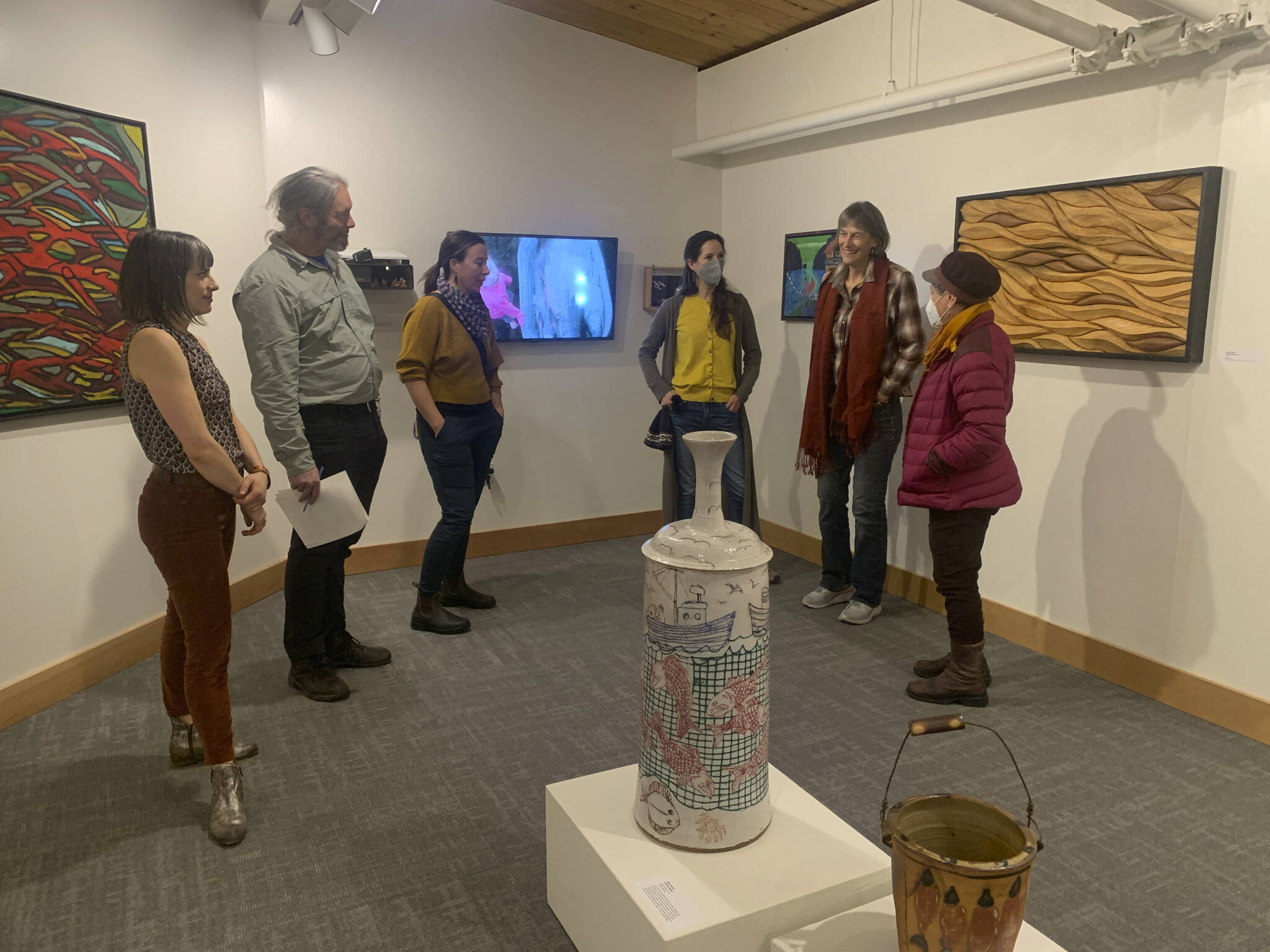 Carla Klinker Cope, far left, and Nadia Jackinski-Sethi, center, co-curators of thethe Pratt Museum & Park’s show “Salmon Culture: Kachemak Bay Connections,” discuss the show in a talk on Friday, Nov. 3, 2022, at the museum. (Photo by Christina Whiting)