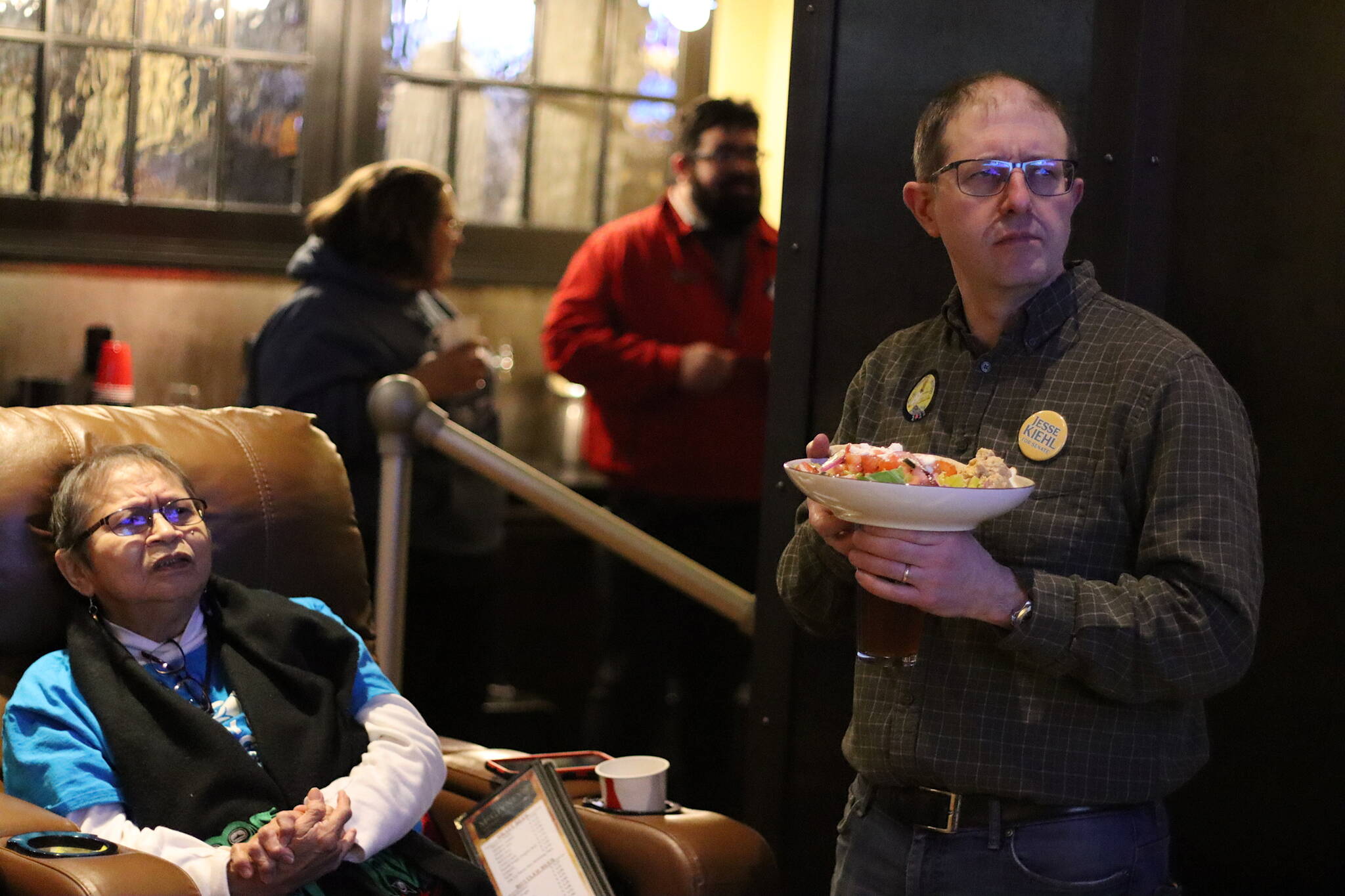 Mark Sabbatini / Juneau Empire
State Sen. Jesse Kiehl of Juneau, right, and lifelong Juneau resident Andrea Ebona Michel monitor election returns Tuesday night at a watch party hosted by U.S. Rep. Mary Peltola’s campaign at McGivney’s Sports Bar Grill downtown. Kiehl, a Democrat, was the lone state senator who was unopposed in his race. Both of Juneau’s Democratic state House representatives also won reelection.