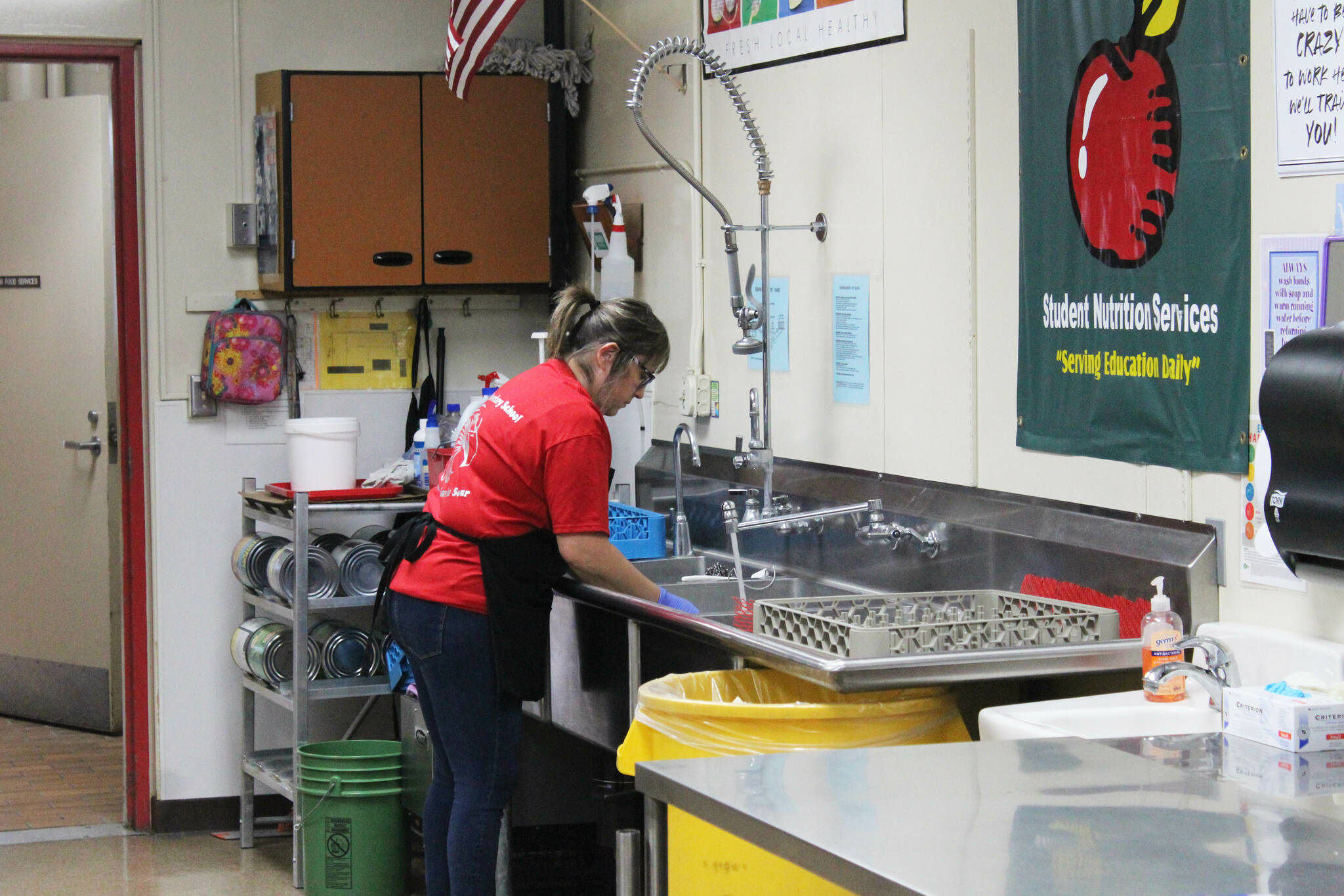 Toni Buchanan washes dishes during lunch time in the cafeteria at Sterling Elementary School on Thursday, Nov. 10, 2022, in Sterling, Alaska. (Ashlyn O’Hara/Peninsula Clarion)