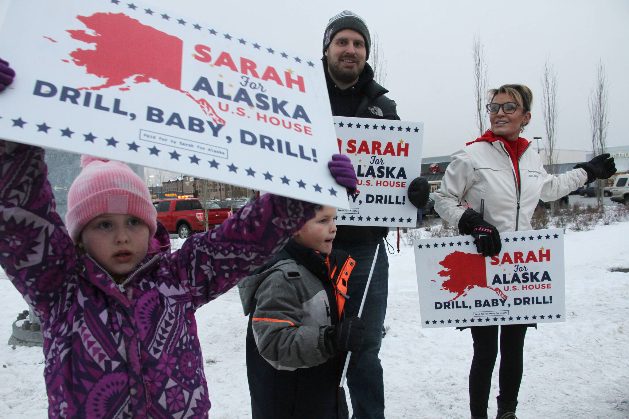 Former Gov. Sarah Palin, a Republican candidate for Alaska’s sole seat in the U.S. House, meets with supporters waving signs on Tuesday in Anchorage. Palin, who is trailing Democratic U.S. Rep. Mary Peltola in the vote count so far, nonetheless is declaring herself the presumptive winner and has named a chief of staff — despite also claiming the election was rigged against her. (AP Photo/Mark Thiessen)