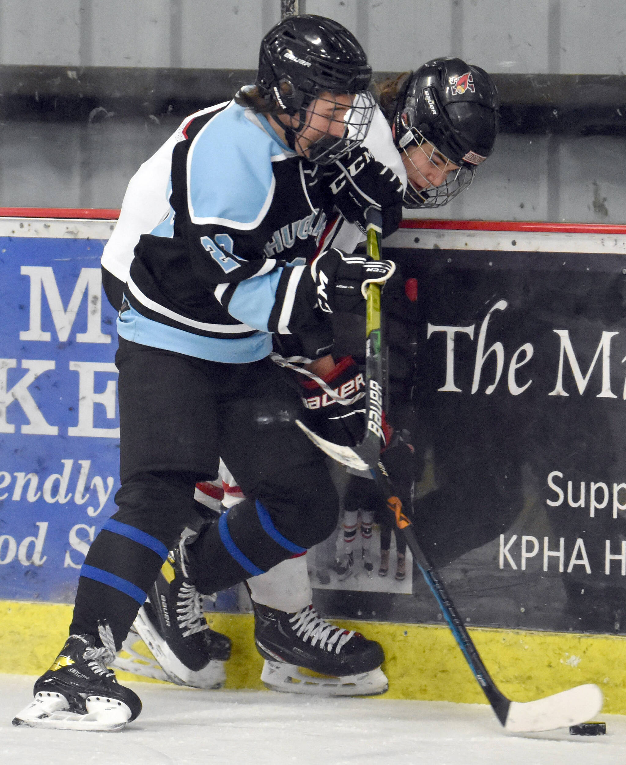 Chugiak’s Brody Phillips and Kenai Central’s Reagan Graves battle for the puck Thursday, Nov. 17, 2022, at the Kenai Multi-Purpose Facility in Kenai, Alaska. (Photo by Jeff Helminiak/Peninsula Clarion)