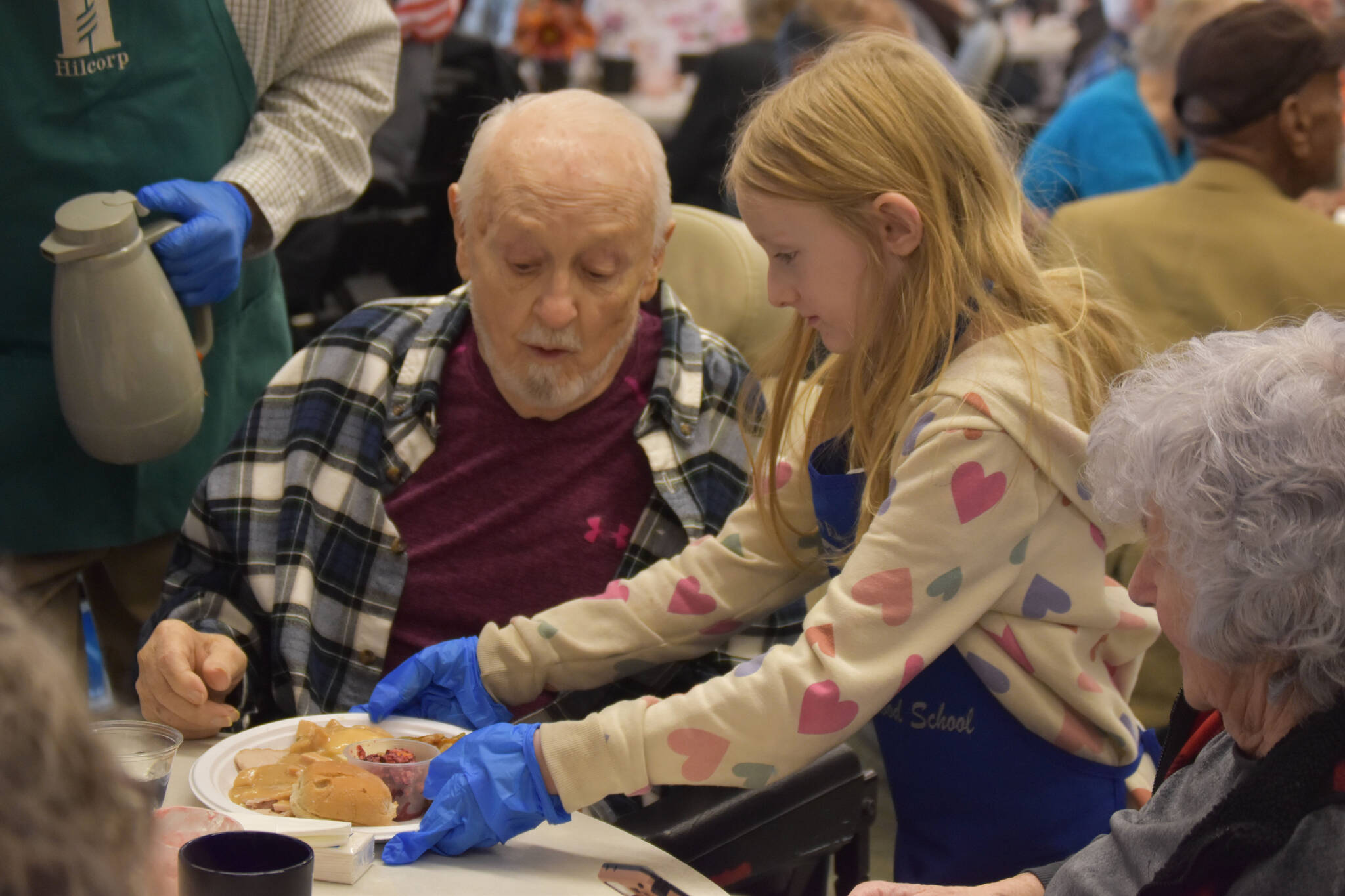 Roy Williams receives a dinner from a student volunteer on Friday, Nov. 18, 2022, at the Area-Wide Senior Dinner at Kenai Seniors Center in Kenai, Alaska. (Jake Dye/Peninsula Clarion)