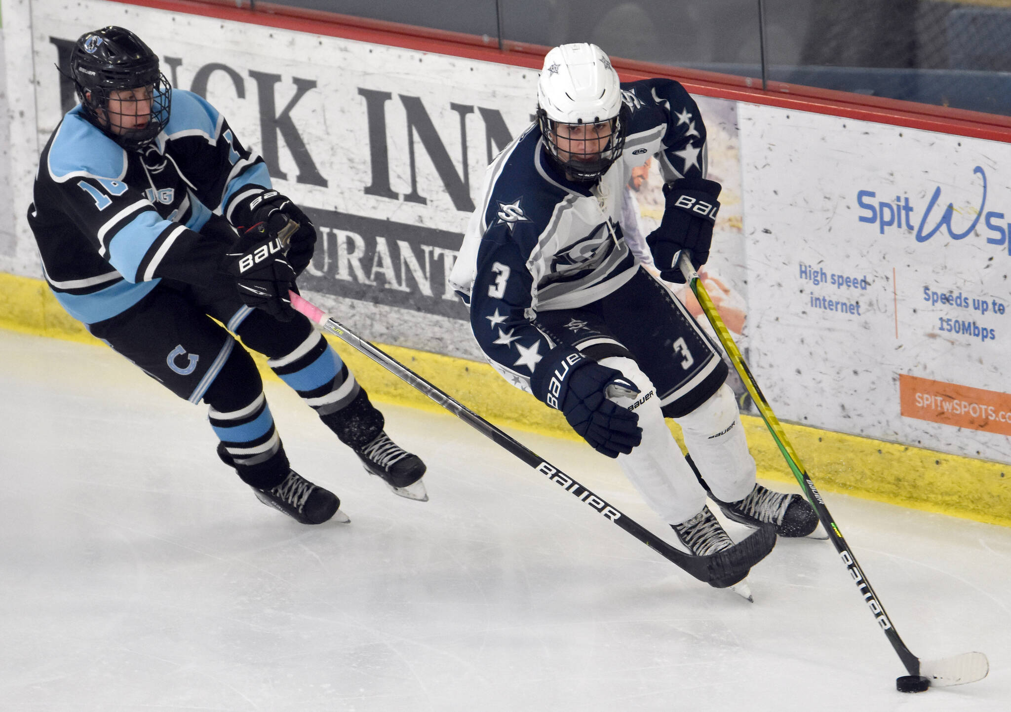 Soldotna’s Andrew Arthur brings the puck out from behind the net under pressure from Chugiak’s Shayden Davis on Friday, Nov. 18, 2022, at the Soldotna Regional Sports Complex in Soldotna, Alaska. (Photo by Jeff Helminiak/Peninsula Clarion)