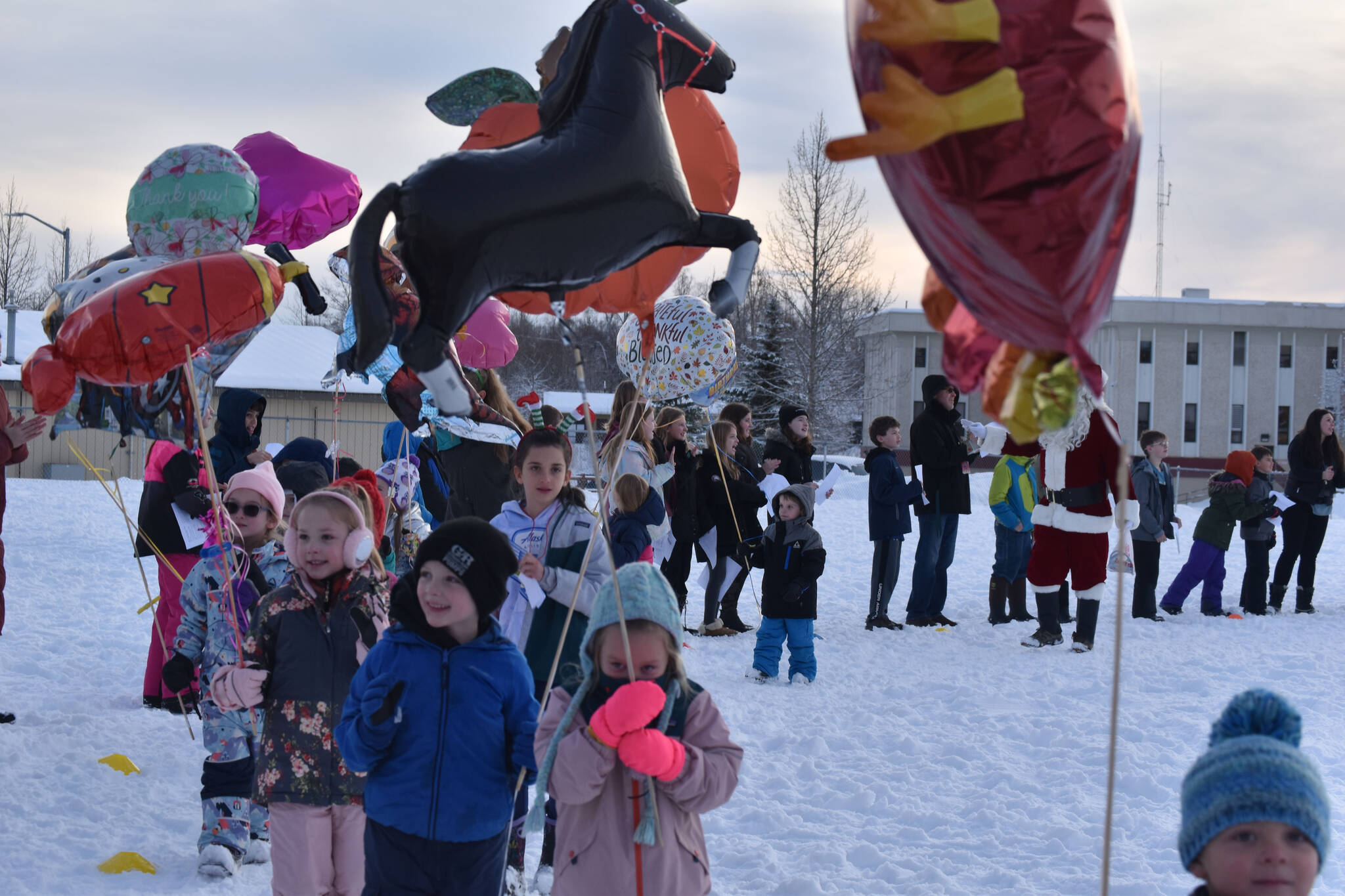 Soldotna Montessori Charter School kindergartners parade with balloons around the school playground on Wednesday, Nov. 23, 2022, in Soldotna, Alaska. (Jake Dye/Peninsula Clarion)