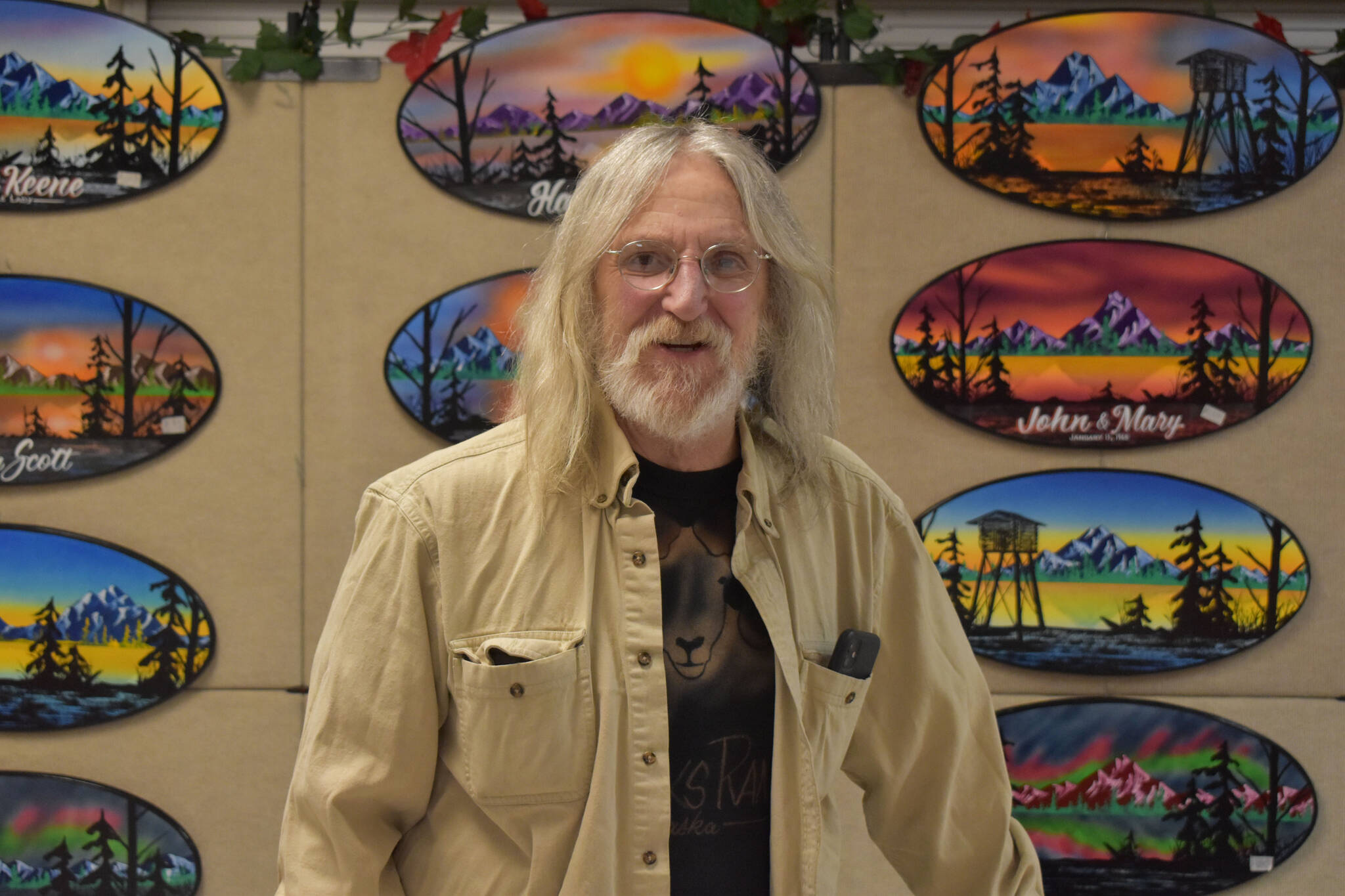 David Hartman, of David Hartman Signs, is seen with his product on display ahead of the Kenai Arts & Crafts Fair during early set up at Kenai Central High School in Kenai, Alaska, on Wednesday, Nov. 23, 2022. (Jake Dye/Peninsula Clarion)