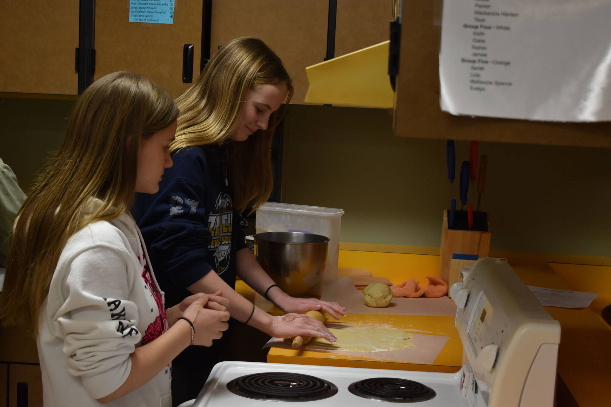 Kenai Central High School Culinary Students roll out dough for Christmas cookies as part of bake sale preparation on Tuesday, Nov. 29, 2022, at Kenai Central High School in Kenai, Alaska. (Jake Dye/Peninsula Clarion)