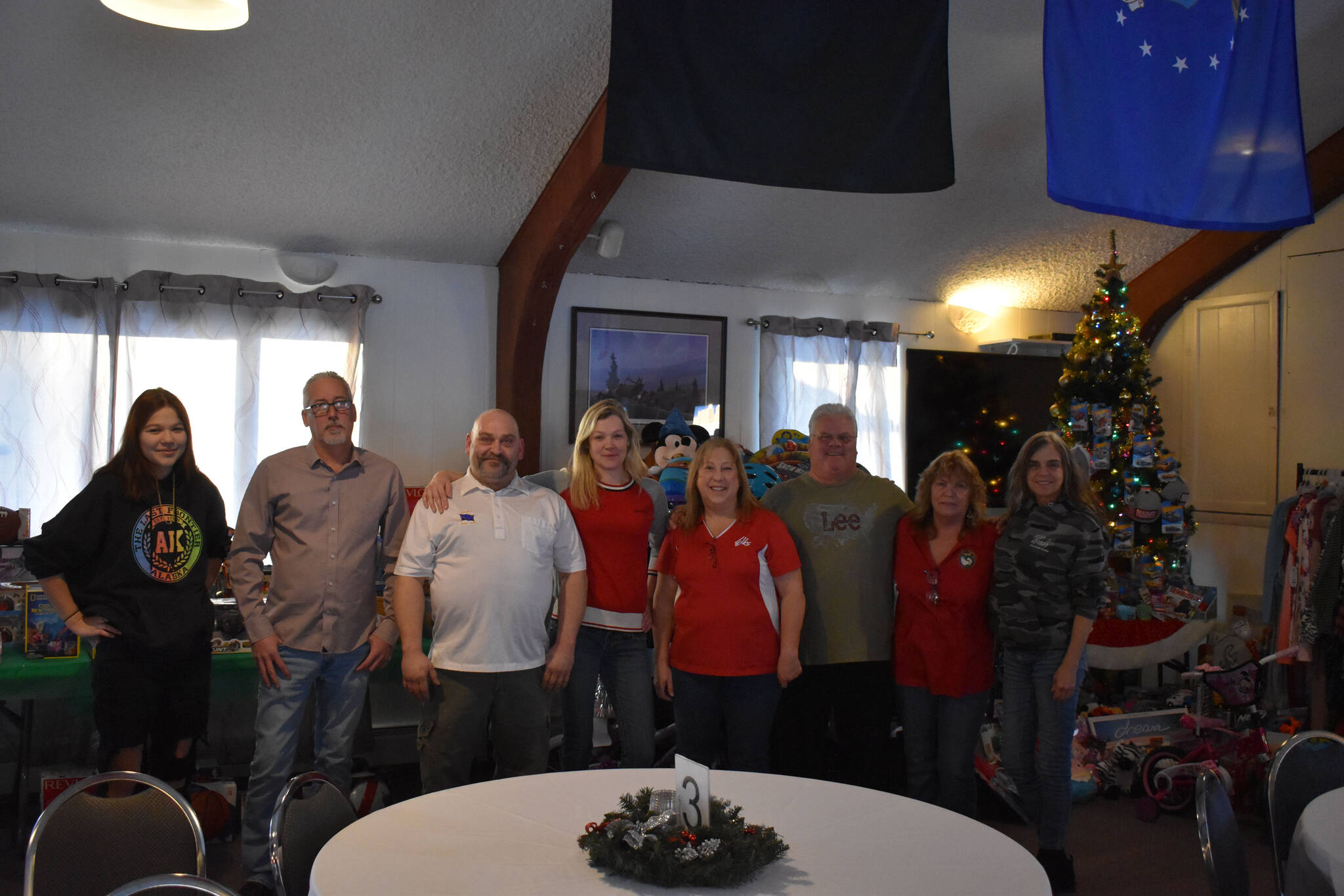 Members of the Soldotna Elks Lodge #2706, including Exalted Ruler Robert Dixon and Secretary Shannon Woodford (third and fifth from the left) stand with purchased toys and clothes for donation to local children at the lodge in Soldotna, Alaska, on Friday, Dec. 2, 2022. (Jake Dye/Peninsula Clarion)