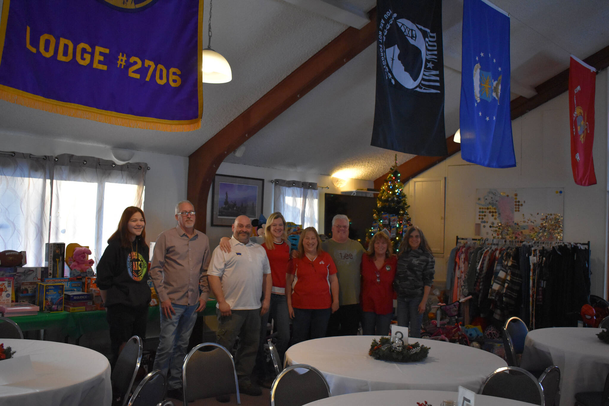 Members of the Soldotna Elks Lodge #2706, including Exalted Ruler Robert Dixon and Secretary Shannon Woodford (third and fifth from the left) stand with purchased toys and clothes for donation to local children at the lodge in Soldotna, Alaska, on Friday, Dec. 2, 2022. (Jake Dye/Peninsula Clarion)