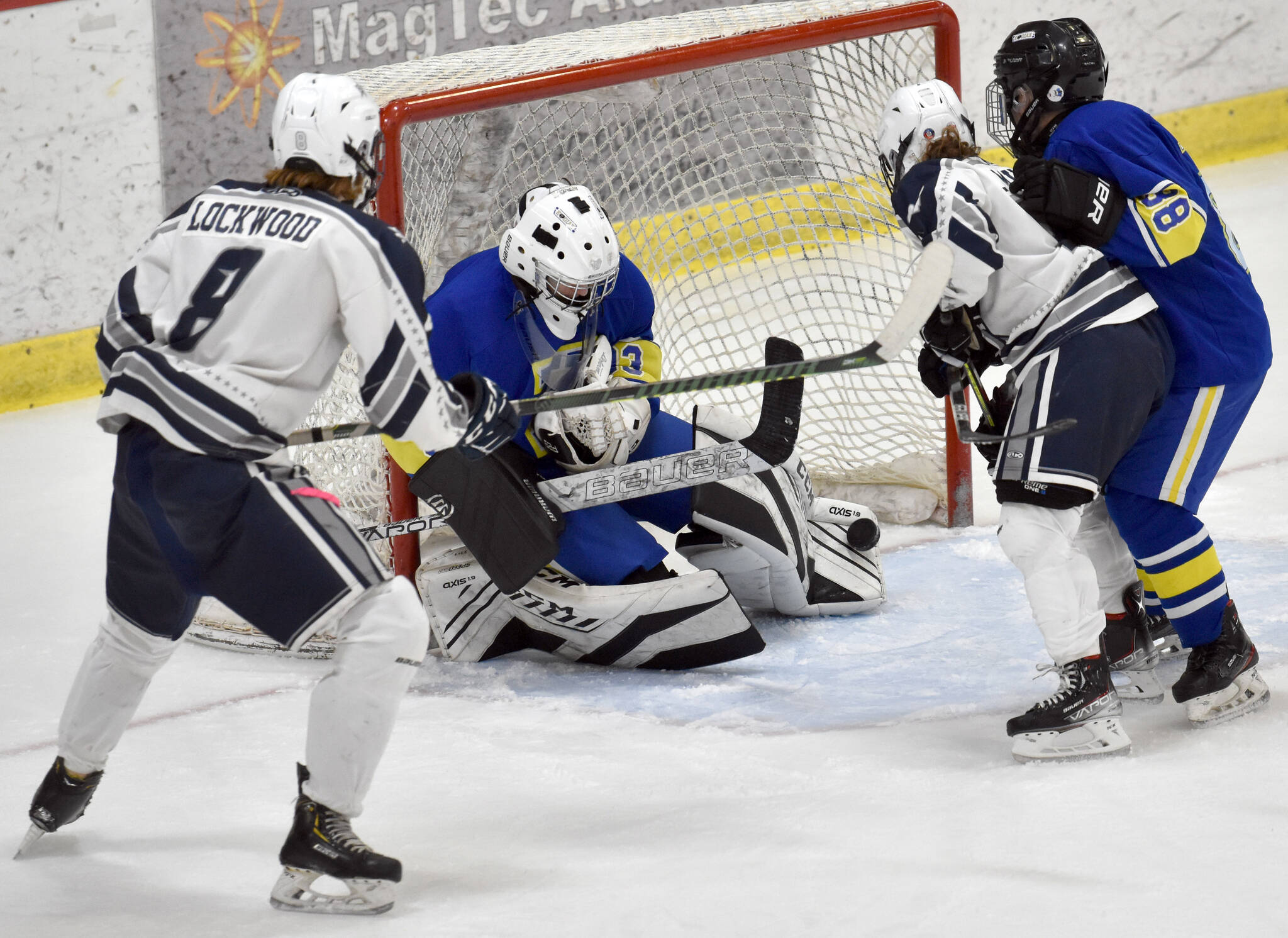 Kodiak goalie Aiden Johnson makes a save in front of Soldotna’s Dawson Lockwood and Libby Miller on Friday, Dec. 2, 2022, at the Soldotna Regional Sports Complex in Soldotna, Alaska. (Photo by Jeff Helminiak/Peninsula Clarion)