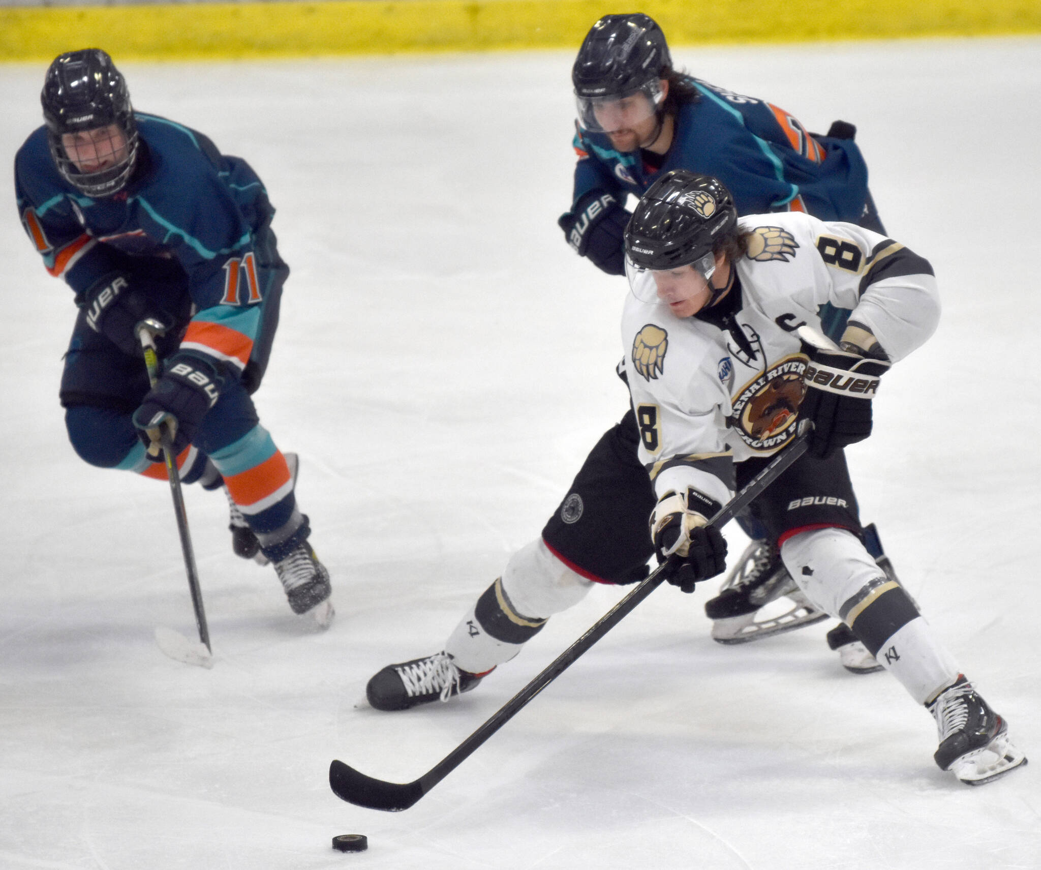 Kenai River Brown Bears forward Noah Holt takes on Luke Anderson and Kade Shea of the Anchorage Wolverines on Saturday, Dec. 3, 2022, at the Soldotna Regional Sports Complex in Soldotna, Alaska. (Photo by Jeff Helminiak/Peninsula Clarion)