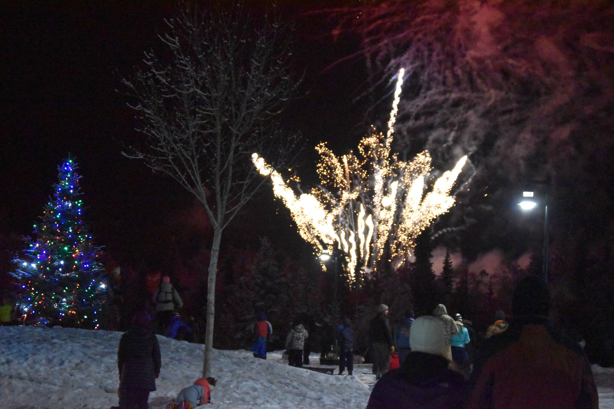 Fireworks explode before a crowd of attendees at Christmas in the Park on Saturday, Dec. 3, 2022, in Soldotna, Alaska. (Jake Dye/Peninsula Clarion)