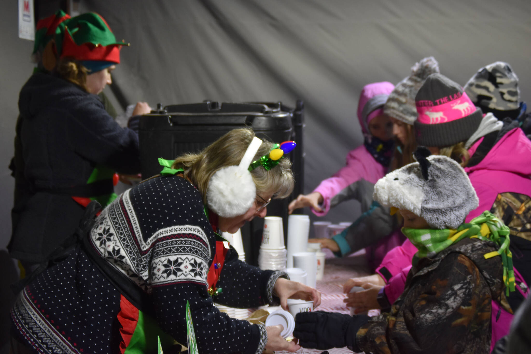 Donated coffee, hot chocolate and cookies are handed out to attendees of Christmas in the Park festivities on Saturday, Dec. 3, 2022, at Soldotna Creek Park in Soldotna, Alaska. (Jake Dye/Peninsula Clarion)
