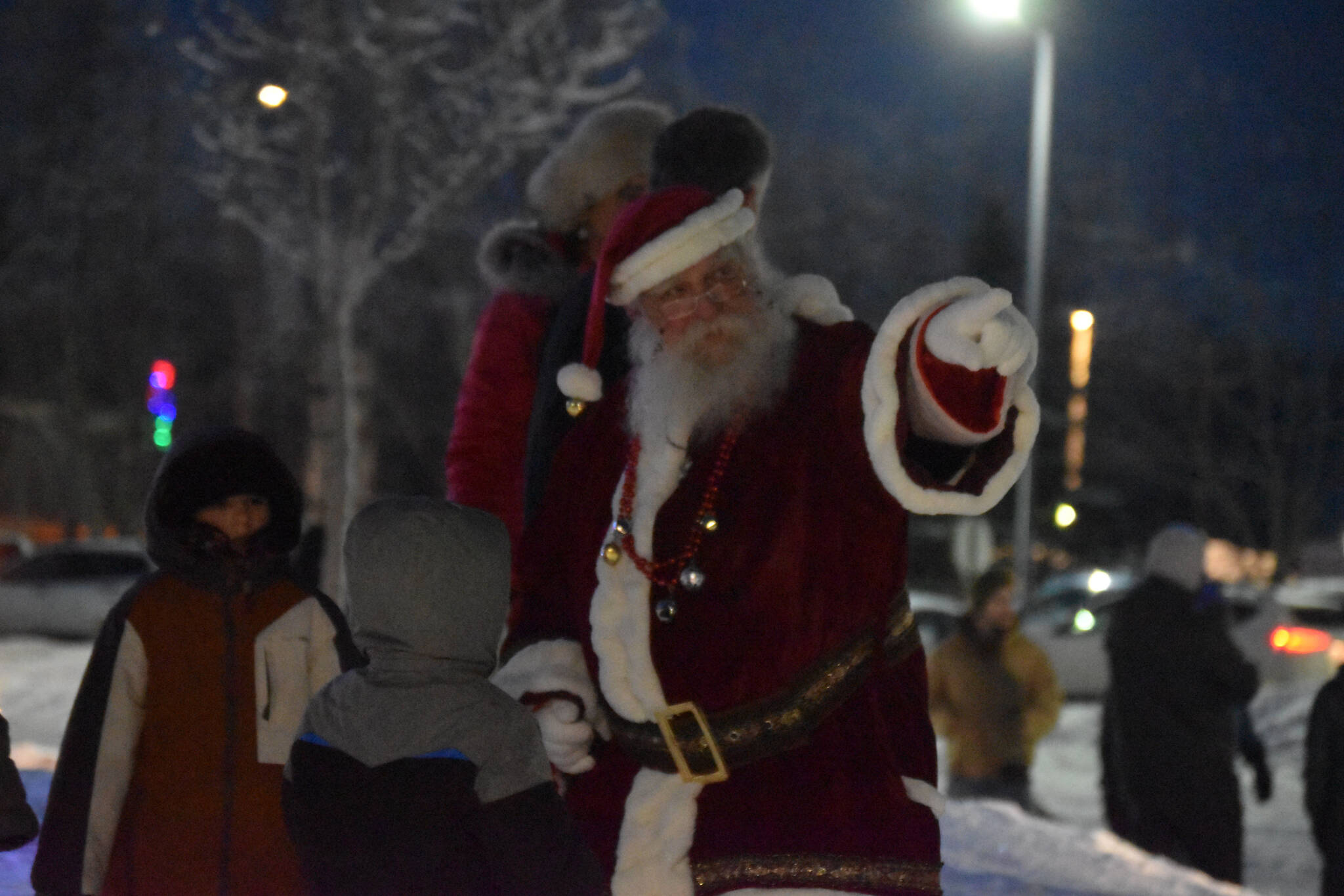 Santa Claus directs children to his stable during Christmas in the Park festivities on Saturday, Dec. 3, 2022, at Soldotna Creek Park in Soldotna, Alaska. (Jake Dye/Peninsula Clarion)