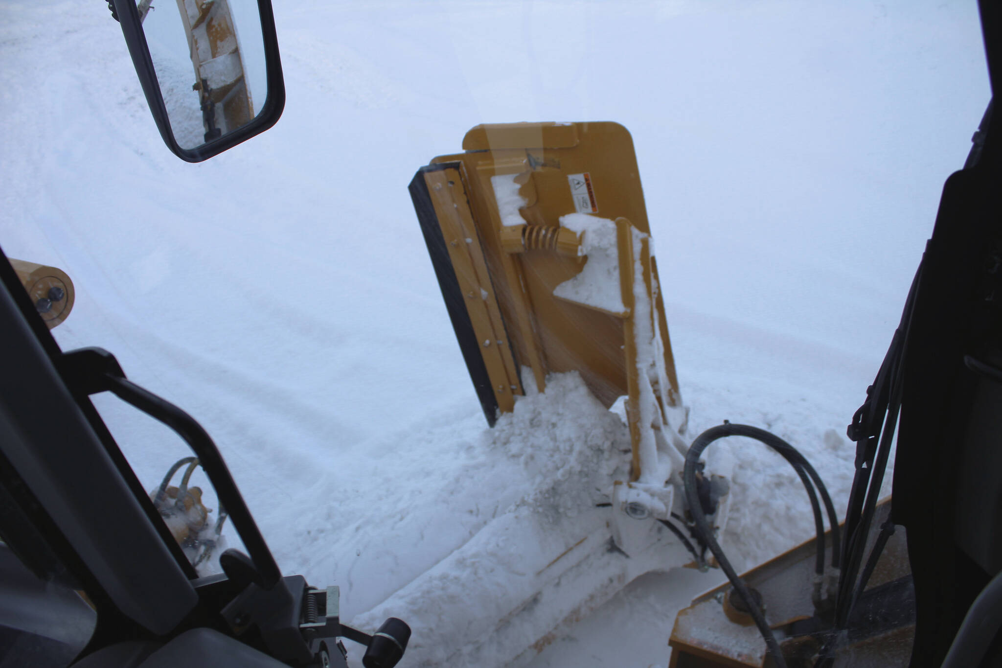A City of Kenai grader collects snow along a roadway on Wednesday, Dec. 7, 2022, in Kenai, Alaska. (Ashlyn O’Hara/Peninsula Clarion)