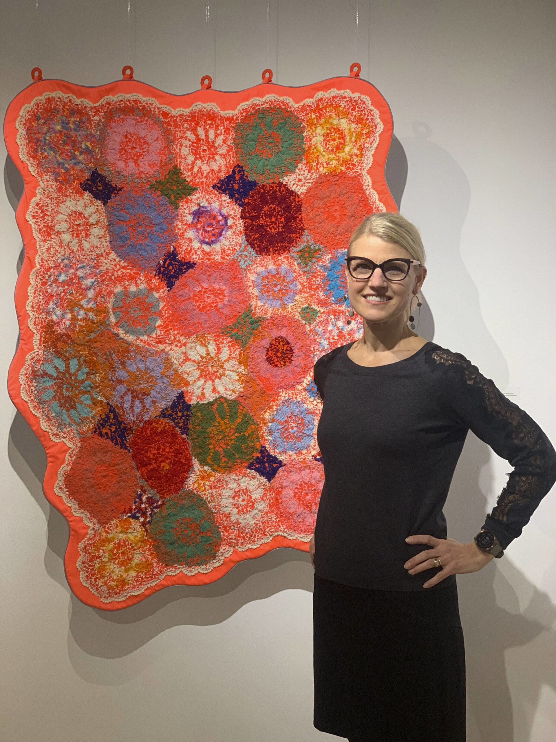 Amy Meissner poses with her work, Survival Blanket, at the opening of the Mother exhibit showing this month at Bunnell Street Arts Center. (Photo by Christina Whiting)