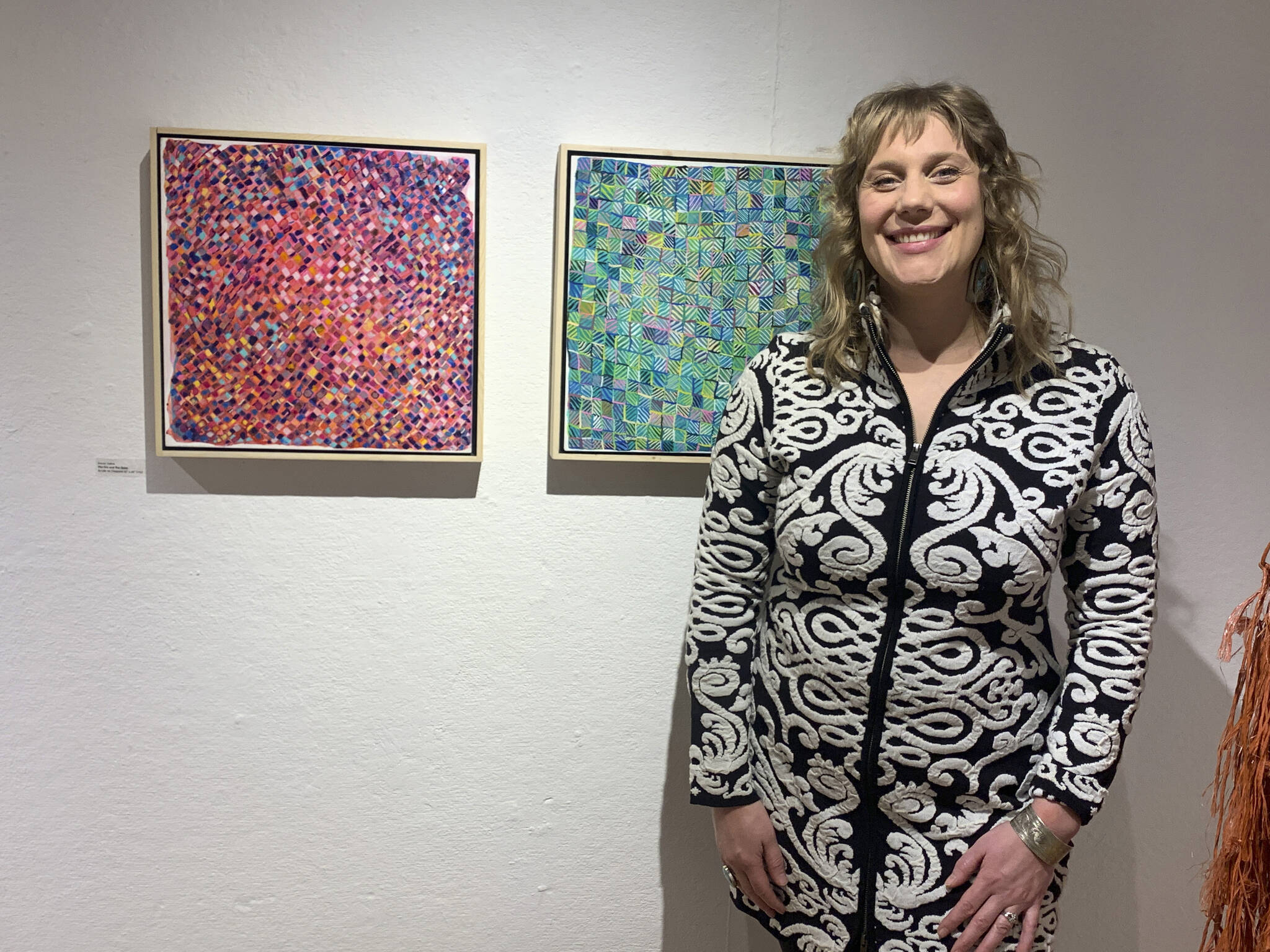 Fairbanks artist Somer Hahm poses with her acrylic on clay board paintings at the opening of the Mother exhibit showing this month at Bunnell Street Arts Center. (Photo by Christina Whiting)