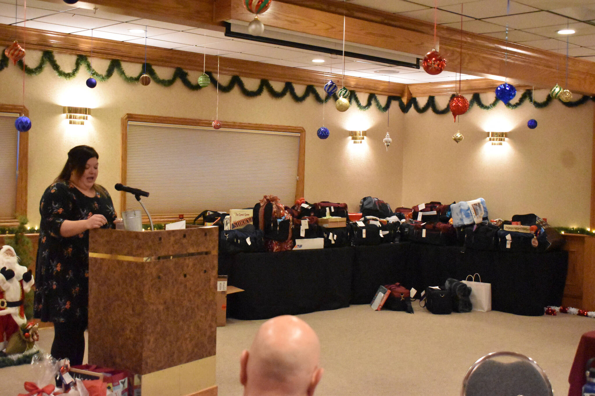 Kelly King, a representative of the Students in Transition program at the Kenai Peninsula Borough School District, speaks to the Kenai Peninsula Association of Realtors about the duffel bag donations on Thursday, Dec. 8, 2022, at Kenai Catering in Kenai, Alaska. (Jake Dye/Peninsula Clarion)