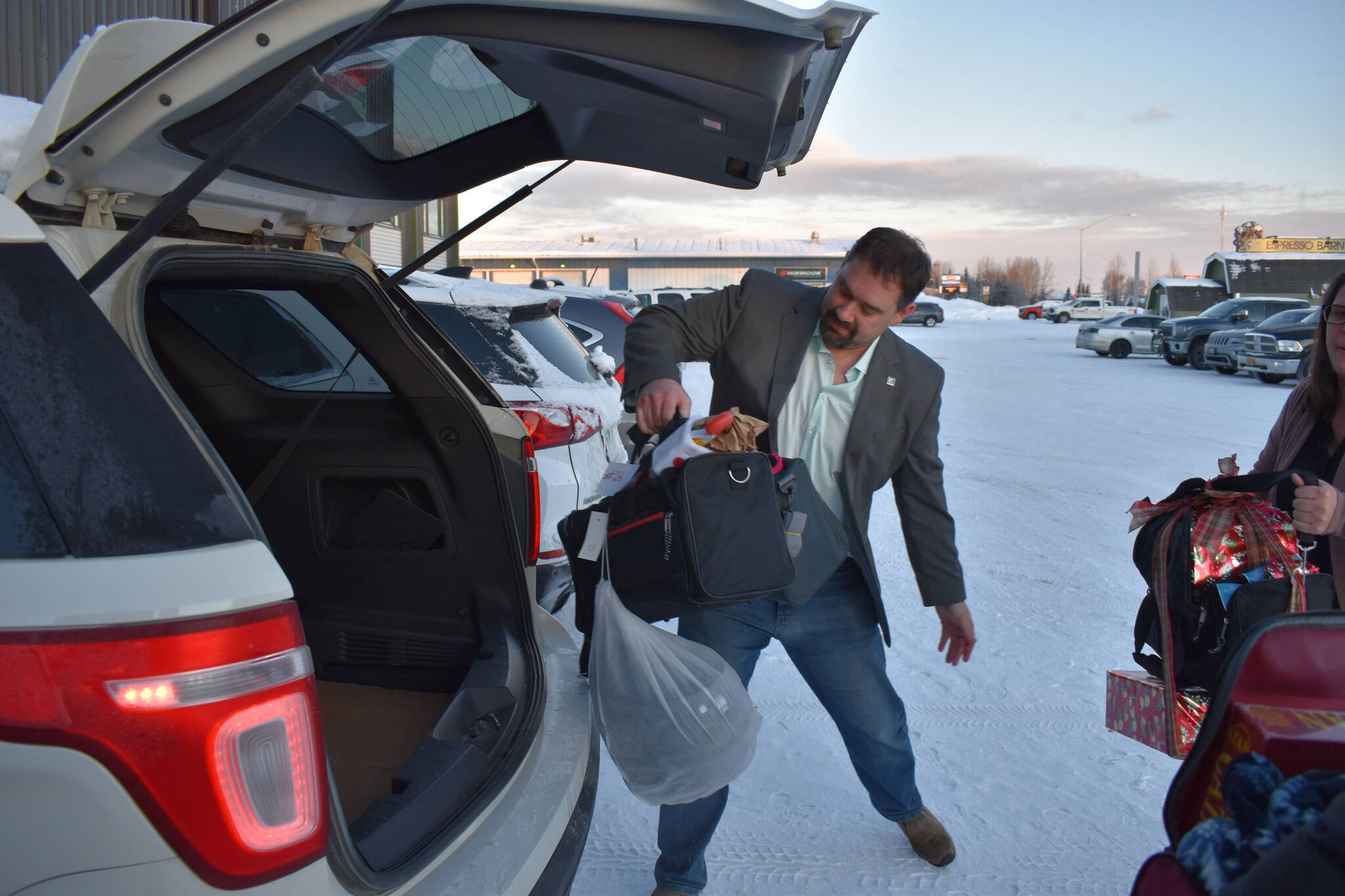 Robert Winter loads duffel bags into a car, part of a donation by the Kenai Peninsula Association of Realtors to the Kenai Peninsula Borough School District’s Students in Transition Program on Thursday, Dec. 8, 2022, at Kenai Catering in Kenai, Alaska. (Jake Dye/Peninsula Clarion)