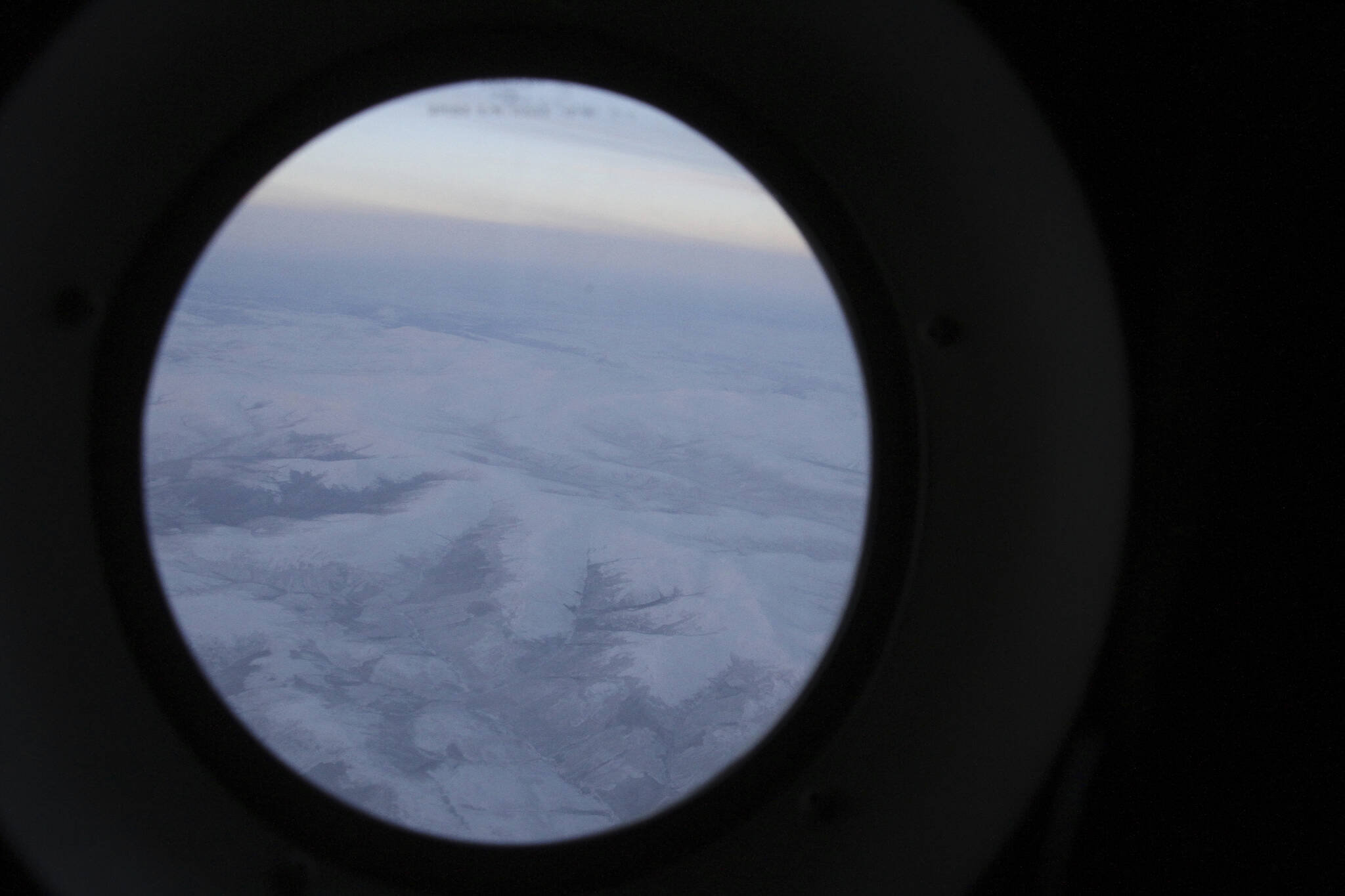 The frozen tundra of northern Alaska is seen out a window of an Alaska National Guard cargo plane en route to Nuiqsut, Alaska, on Tuesday, Nov. 29, 2022. Operation Santa Claus, the Alaska National Guard’s outreach program, attempts to bring Santa and Mrs. Claus and gifts to children in two or three Alaska Native villages each year, including Nuiqsut in 2022. (AP Photo/Mark Thiessen)