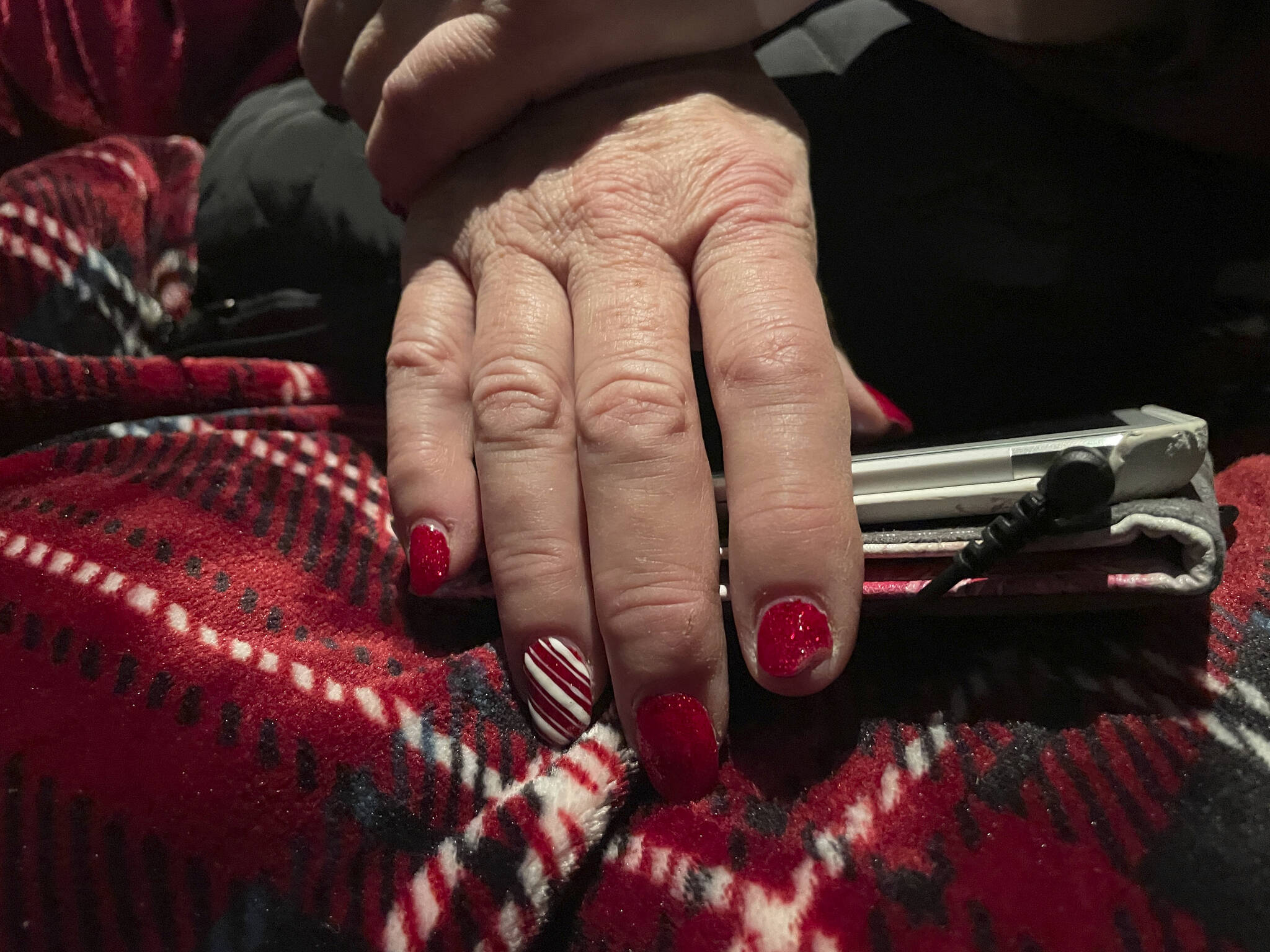 This photo shows Mrs. Claus’ holiday-themed fingernails during a plane ride trip to Nuiqsut, Alaska, on Tuesday, Nov. 29, 2022. Operation Santa Claus, the Alaska National Guard’s outreach program, attempts to bring Santa and Mrs. Claus and gifts to children in two or three Alaska Native villages each year. (AP Photo/Mark Thiessen)