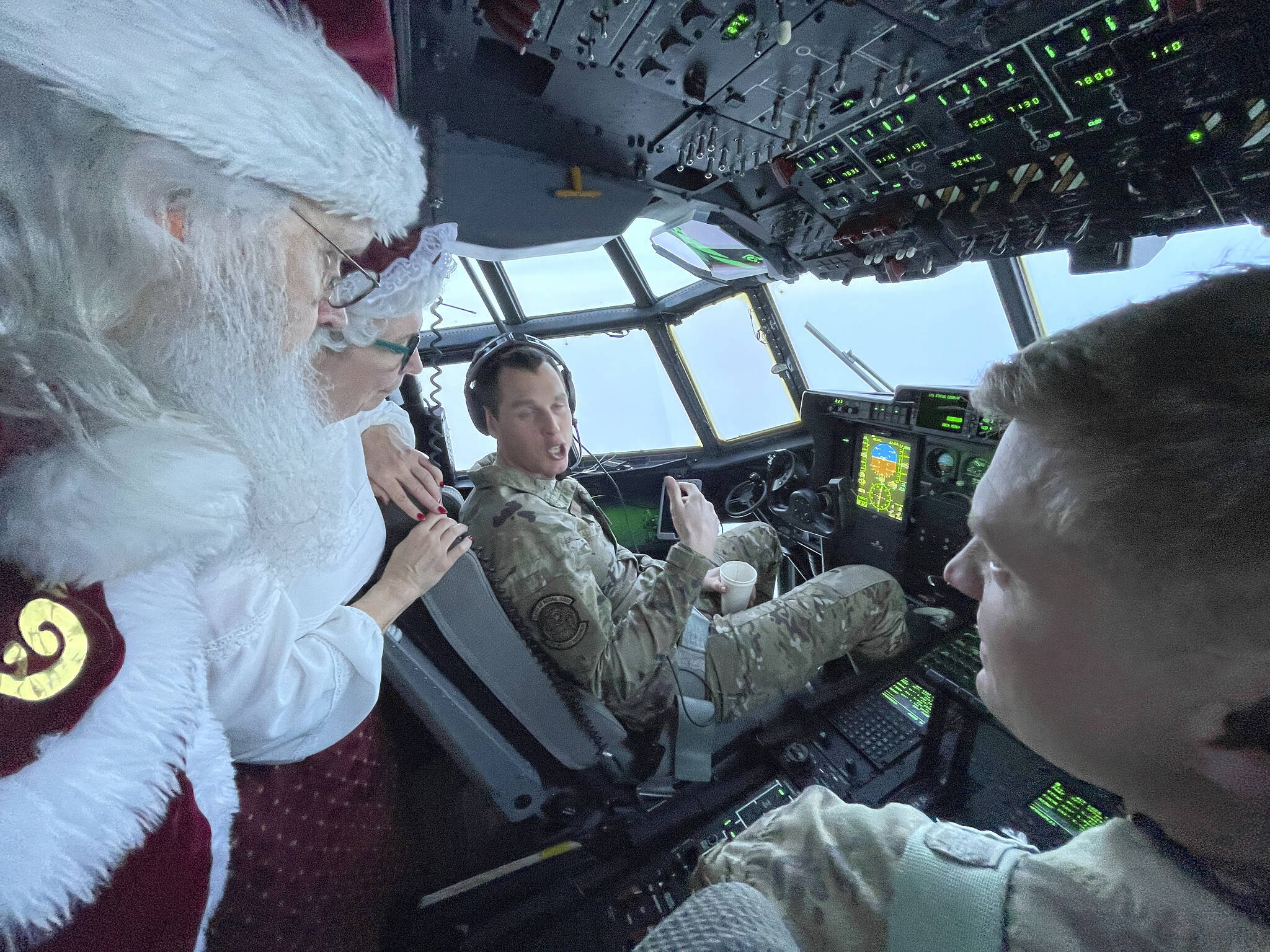 Santa and Mrs. Claus chat with the flight crew of an Alaska National Guard cargo plane while en route to Nuiqsut, Alaska, on Tuesday, Nov. 29, 2022. Operation Santa Claus, the guard’s outreach program, attempts to bring Santa and Mrs. Claus and gifts to children in two or three Alaska Native villages each year. (AP Photo/Mark Thiessen)