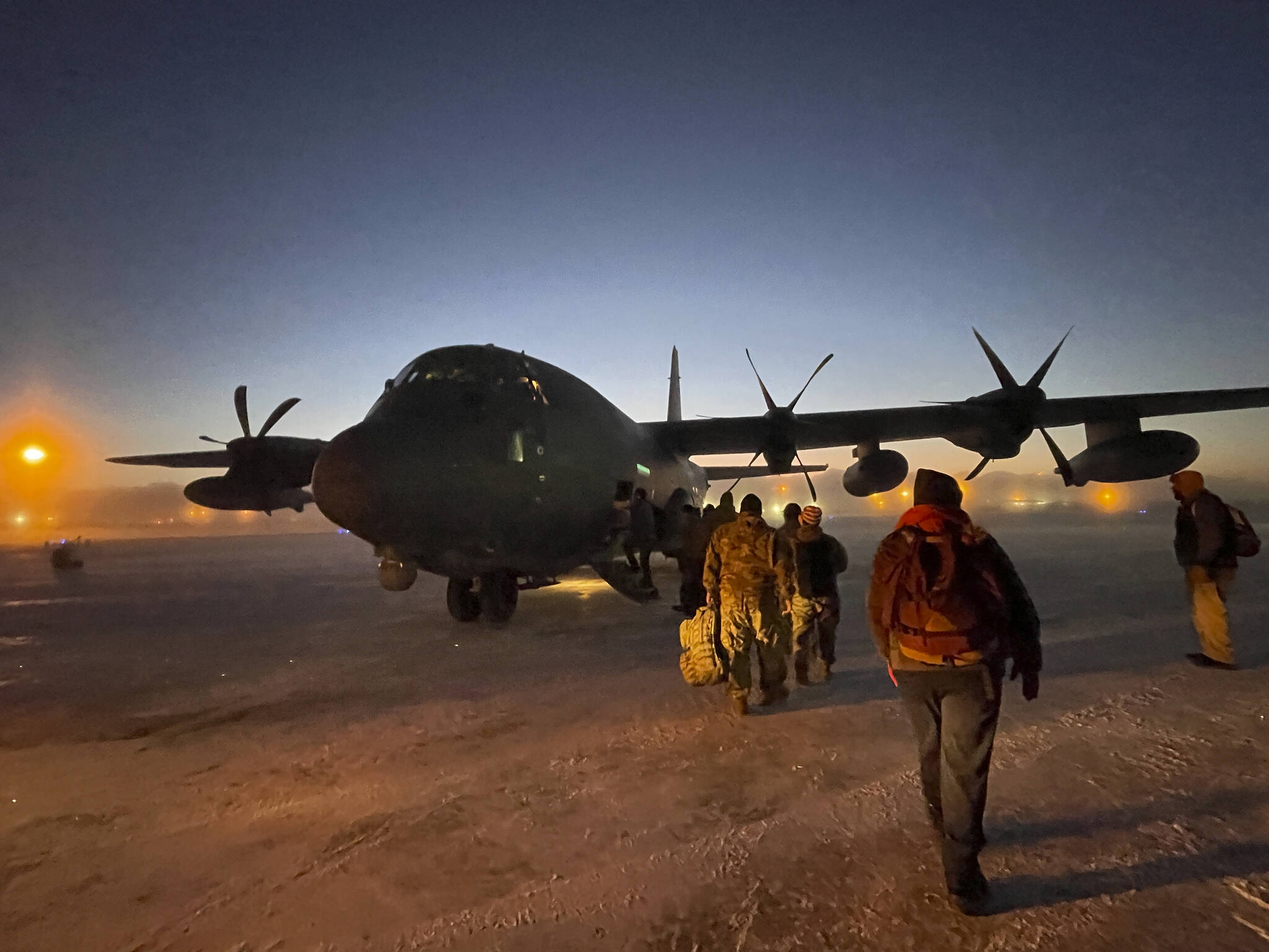 Helpers in the Alaska National Guard’s Operation Santa Claus board a cargo plane at Joint Base Elmendorf-Anchorage on Tuesday, Nov. 29, 2022, for a flight to Nuiqsut, Alaska. The guard’s outreach program attempts to bring Santa and Mrs. Claus and gifts to children in two or three Alaska Native villages each year. (AP Photo/Mark Thiessen)