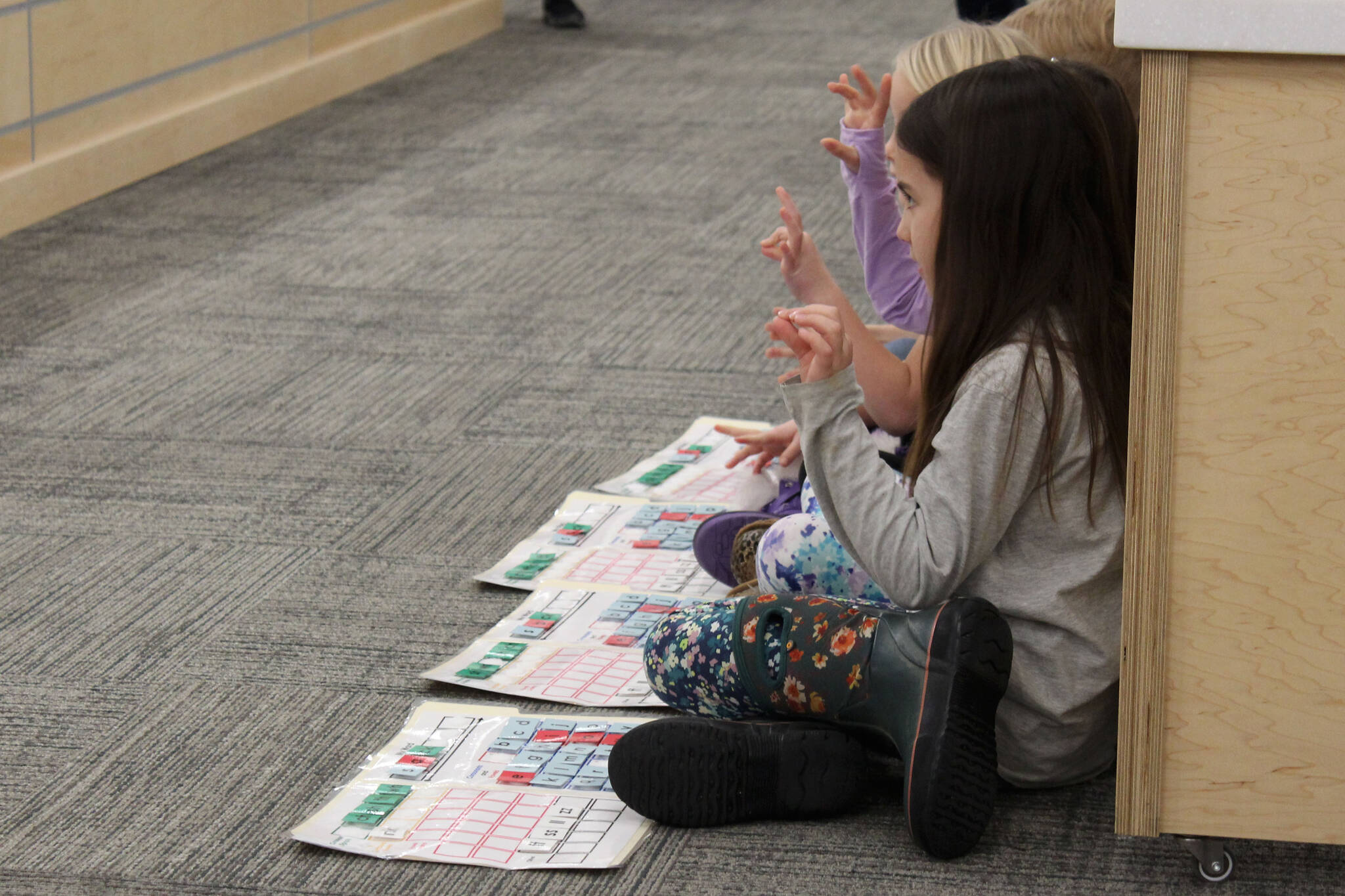 Mountain View Elementary School students use their hands to build works using methodology from the University of Florida Literacy Institute during a board of education meeting on Monday, Dec. 5, 2022, in Soldotna, Alaska. (Ashlyn O’Hara/Peninsula Clarion)