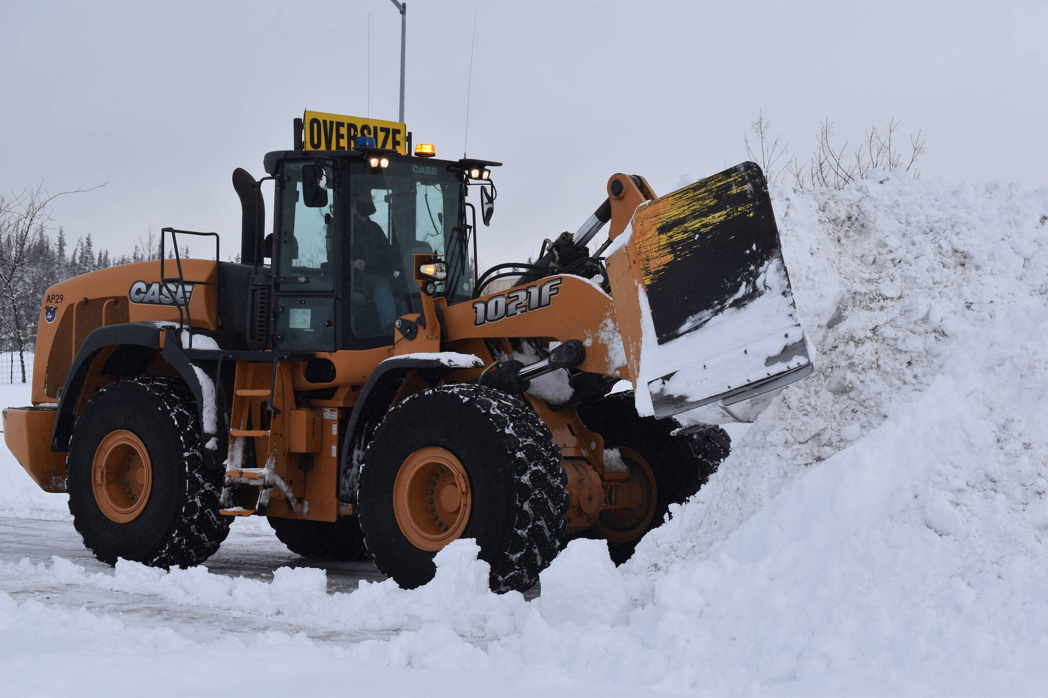 Snow is cleared from a parking lot at the Kenai Municipal Airport on Wednesday, Nov. 2, 2022, in Kenai, Alaska. (Jake Dye/Peninsula Clarion)