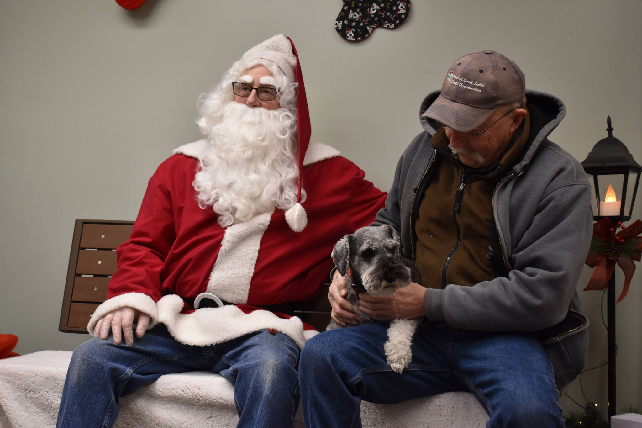 Rowdy sits calmly with Santa Claus and his owner during Bark, Block and Bowl on Saturday, Dec. 10, 2022, at the Kenai Peninsula Food Bank in Soldotna, Alaska. (Jake Dye/Peninsula Clarion)