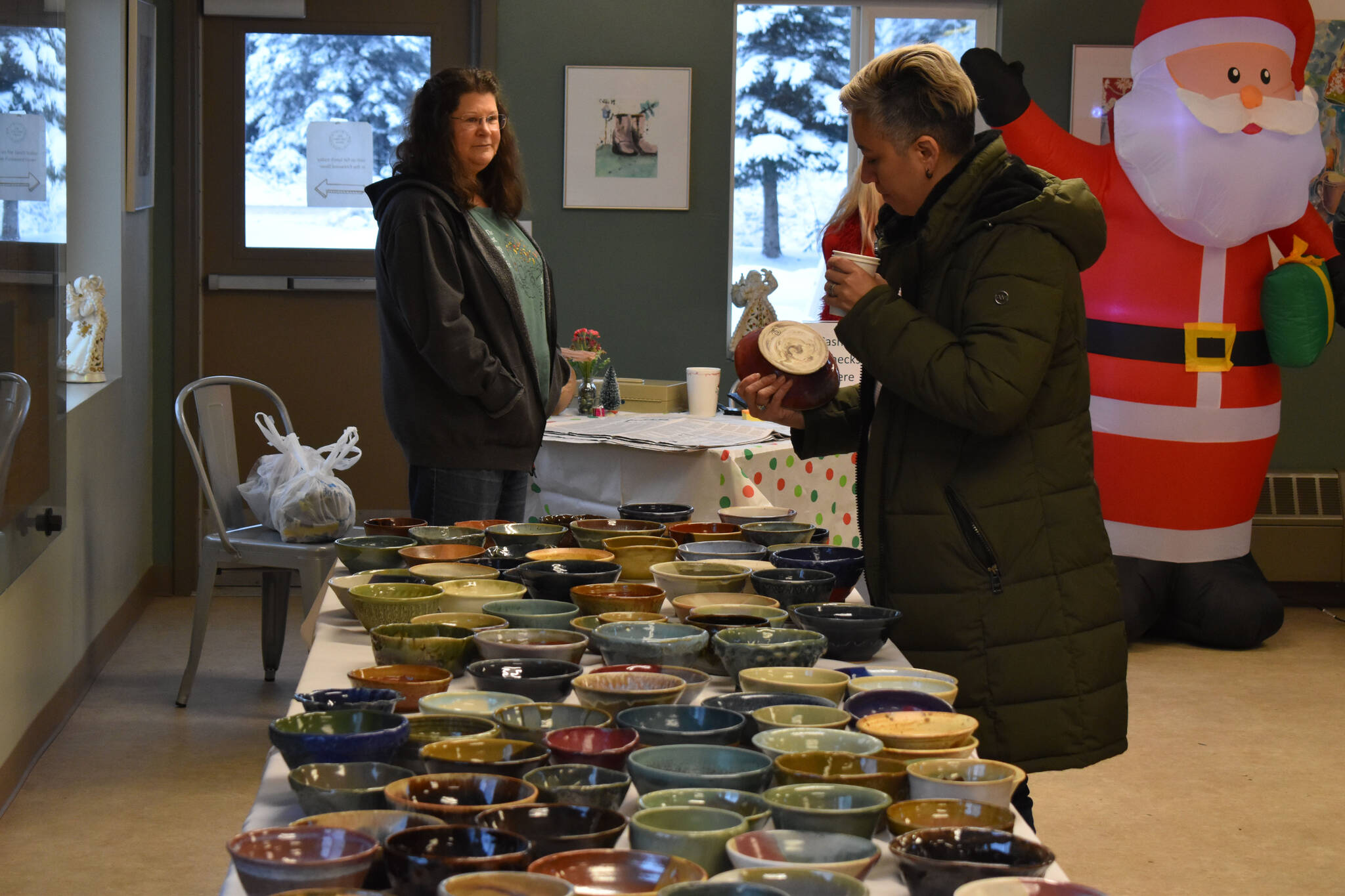 An attendee checks out the ceramic soup bowls during Bark, Block and Bowl on Saturday, Dec. 10, 2022, at the Kenai Peninsula Food Bank in Soldotna, Alaska. (Jake Dye/Peninsula Clarion)