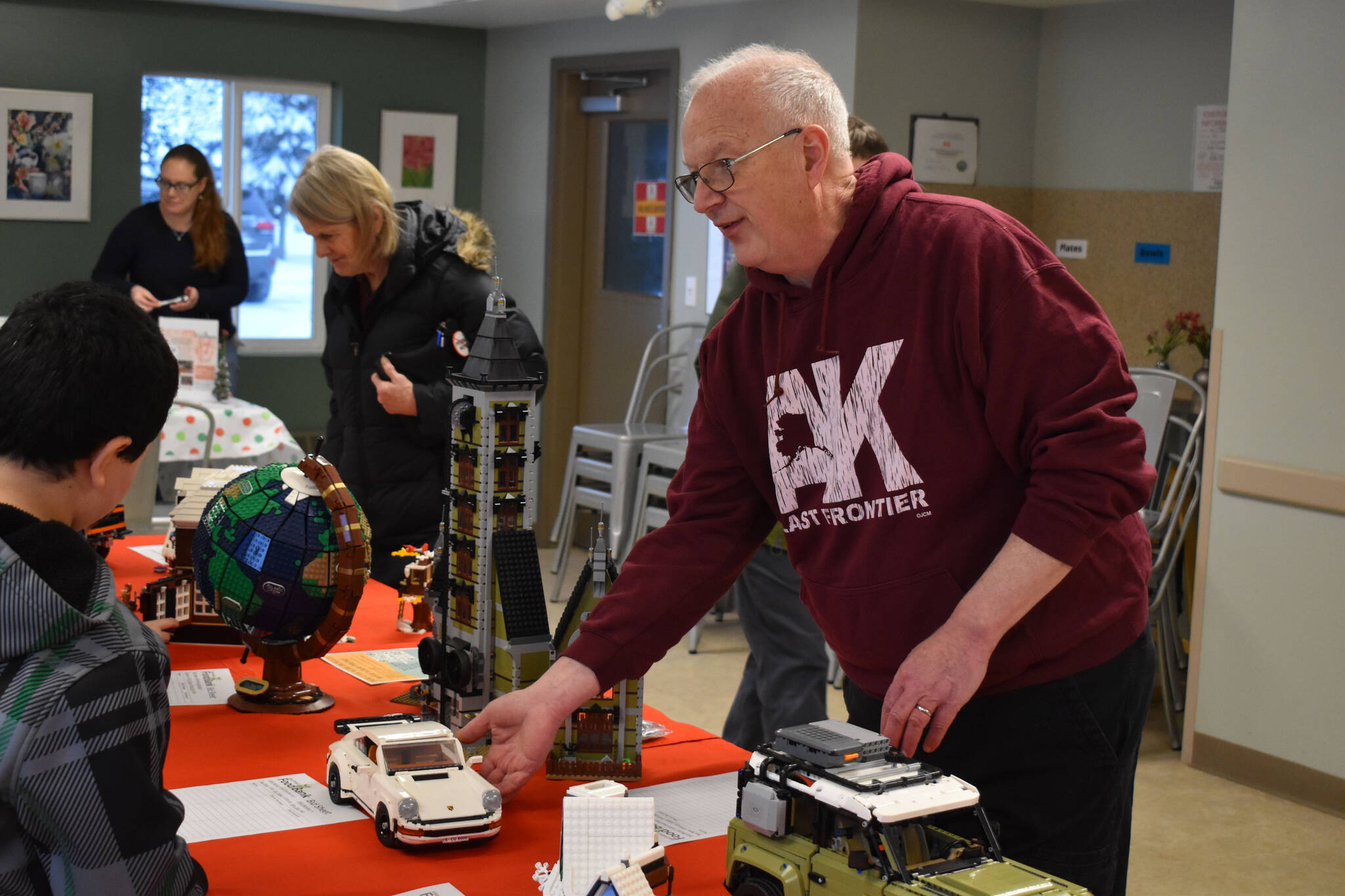 Greg Meyer shows off the Lego sets he built as they are put on auction during Bark, Block and Bowl on Saturday, Dec. 10, 2022, at the Kenai Peninsula Food Bank in Soldotna, Alaska. (Jake Dye/Peninsula Clarion)