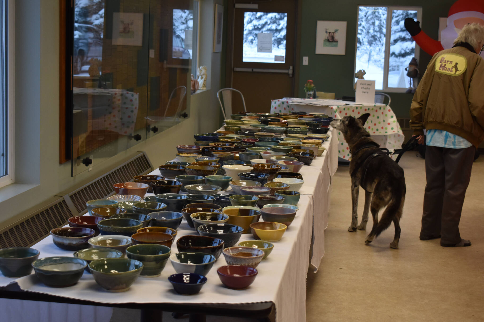 Blue sniffs the soup bowls during Bark, Block and Bowl on Saturday, Dec. 10, 2022, at the Kenai Peninsula Food Bank in Soldotna, Alaska. (Jake Dye/Peninsula Clarion)