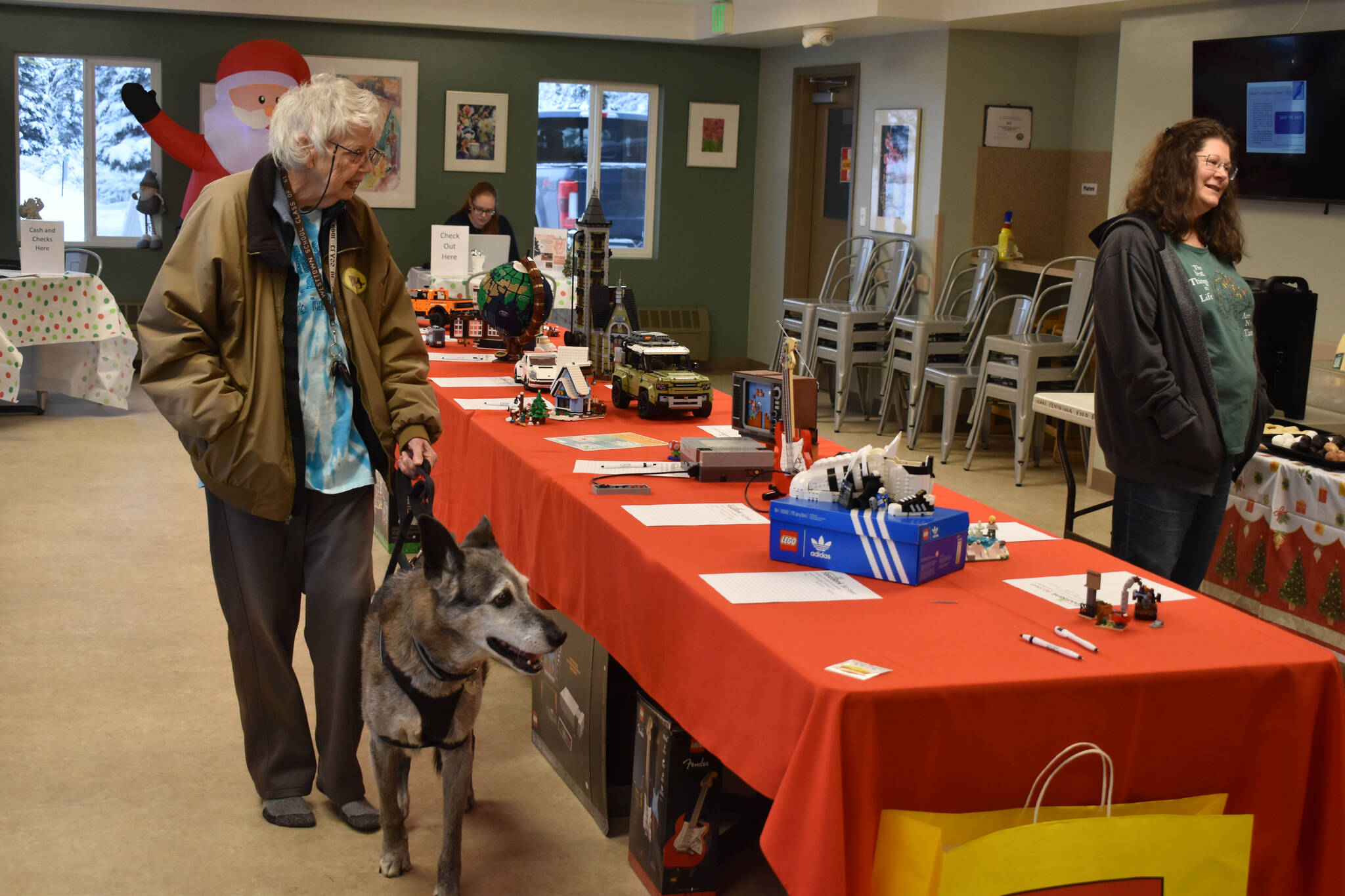 Blue peruses the Lego sets being auctioned off with his owner during Bark, Block and Bowl on Saturday, Dec. 10, 2022, at the Kenai Peninsula Food Bank in Soldotna, Alaska. (Jake Dye/Peninsula Clarion)
