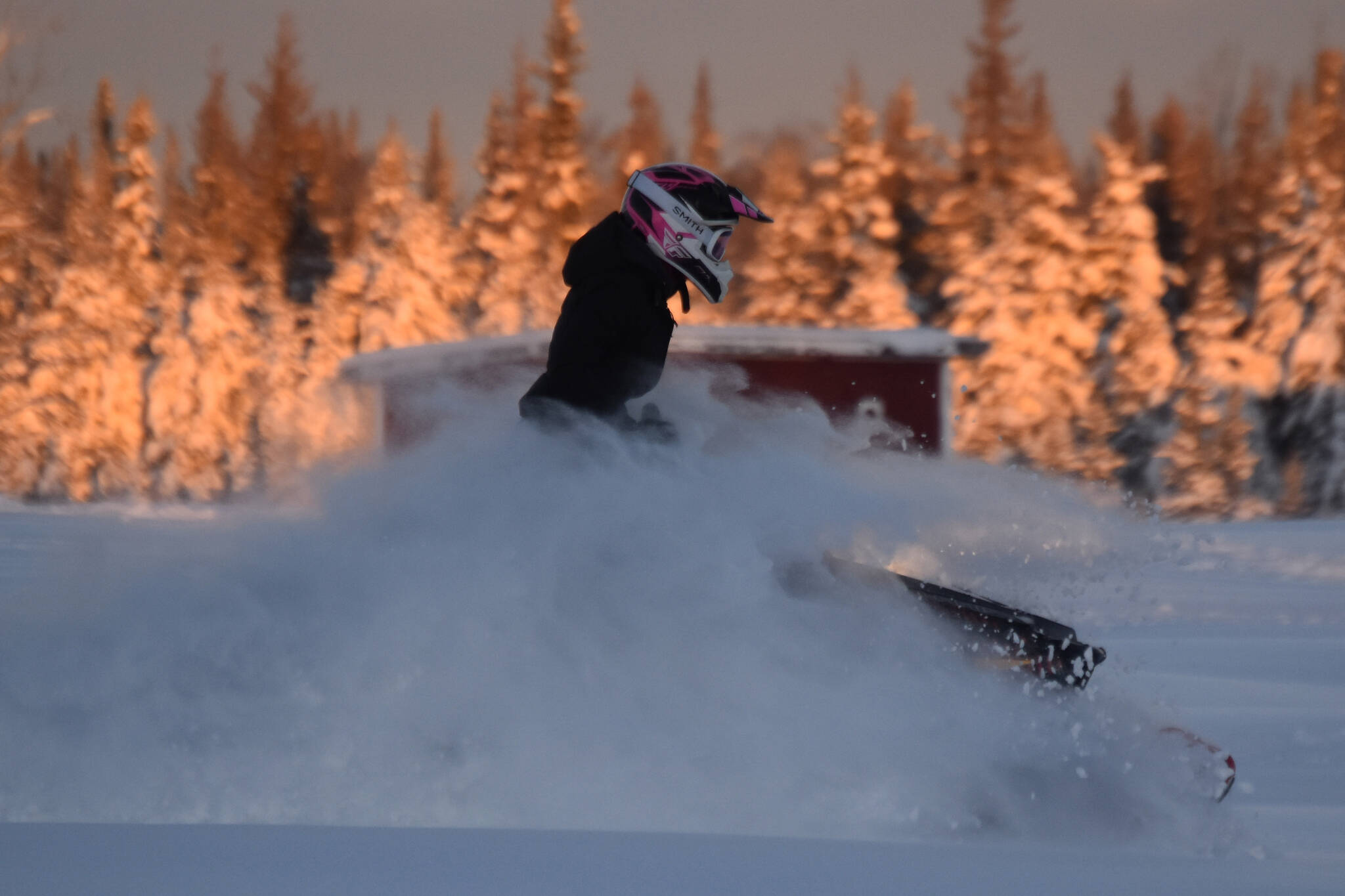 A snowmachine rider takes advantage of 2 feet of fresh snow on a field down Murwood Avenue in Soldotna, Alaska, on Monday, Dec. 12, 2022. (Jake Dye/Peninsula Clarion)