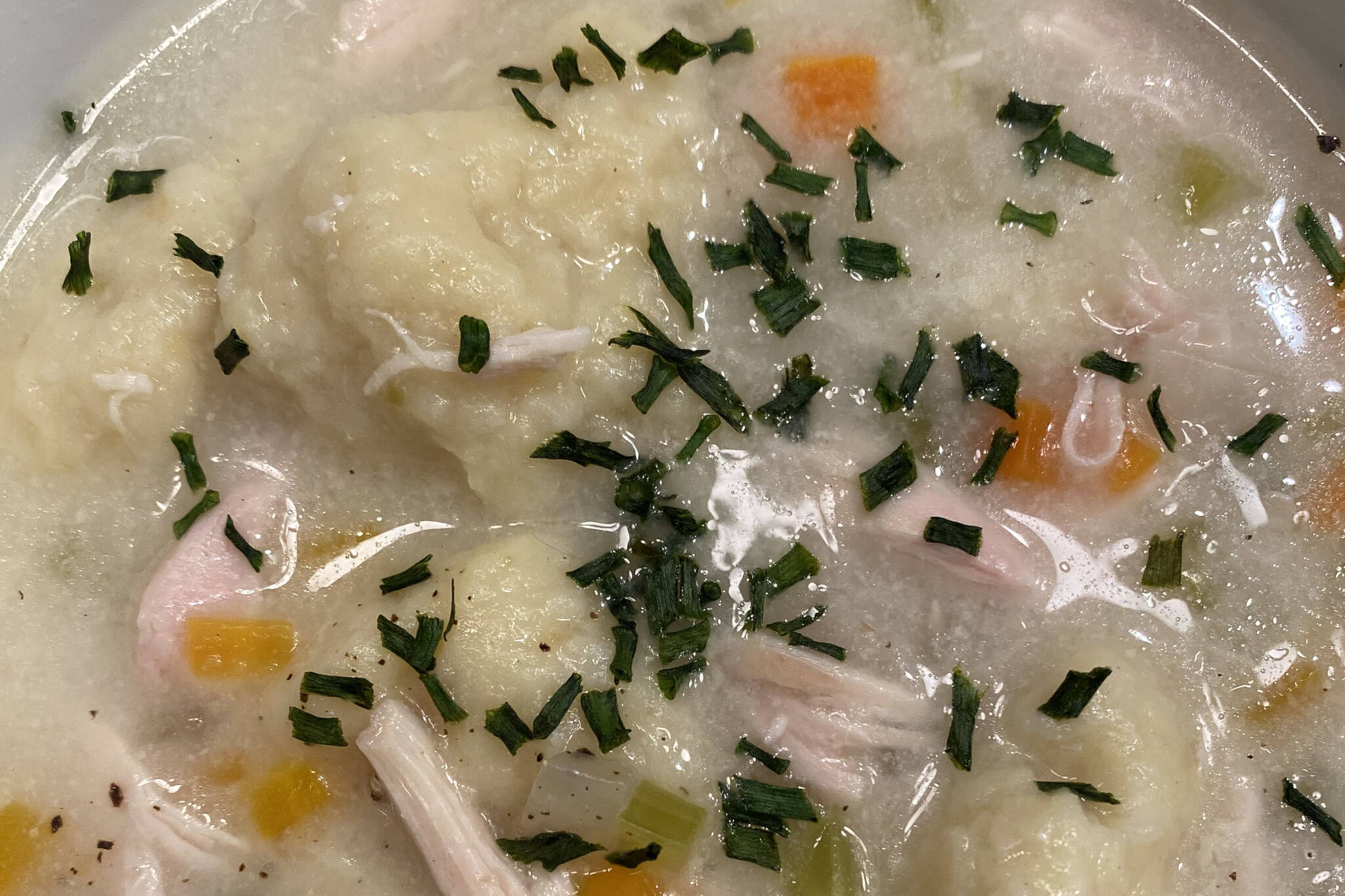 Onions, carrots and chicken broth are topped off with warm dumplings in this classic recipe. (Photo by Tressa Dale/Peninsula Clarion)