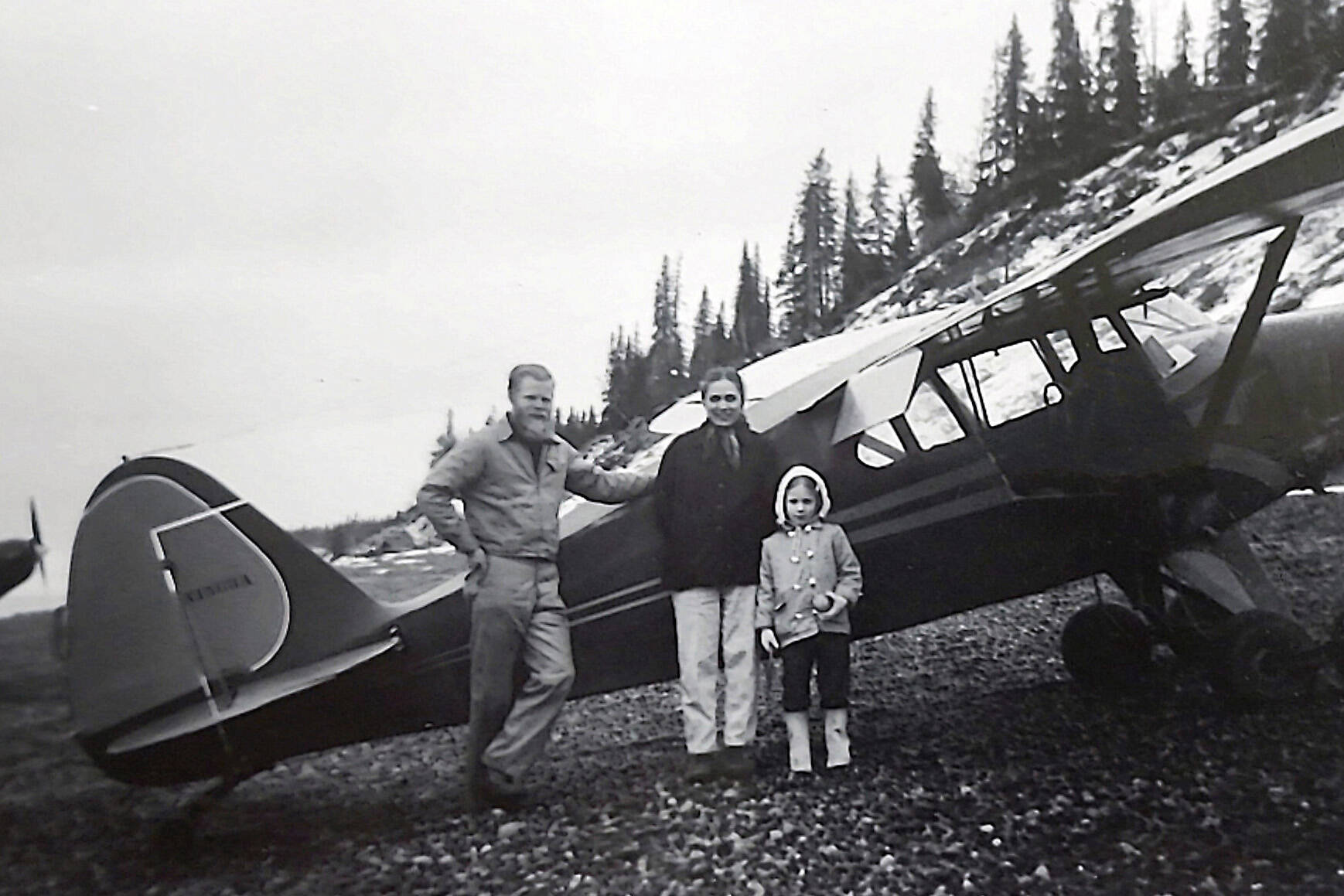 Photo courtesy of Ben and Marian Goble 
Ben, Marian and Grace Goble pose next to Ben’s airplane on the beach near Kenai in 1959.