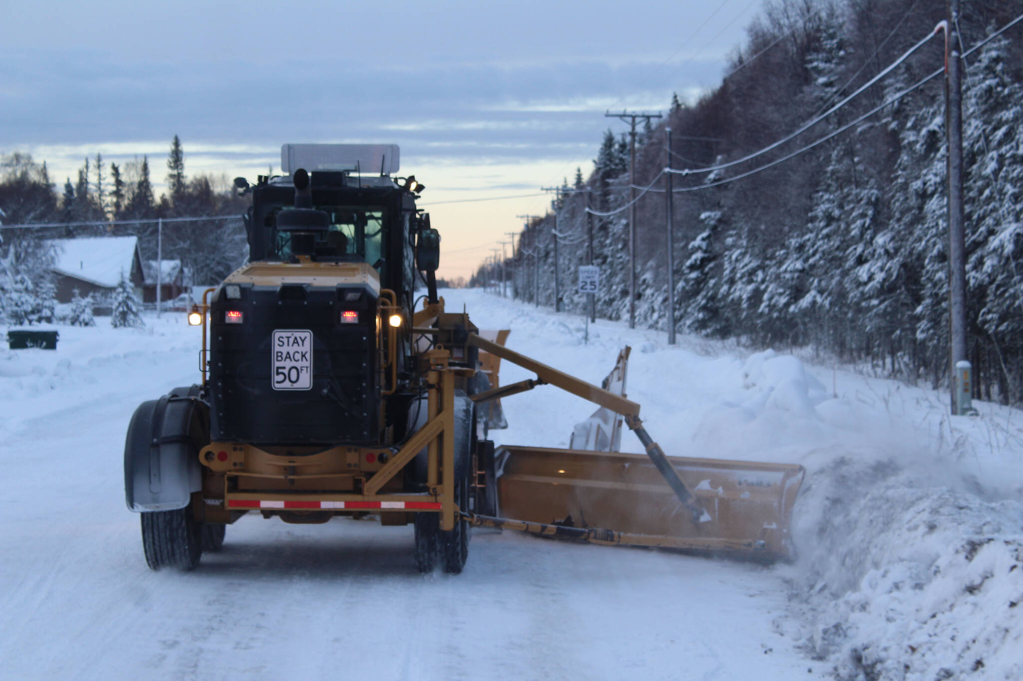 A City of Kenai grader moves snow from a roadway on Wednesday, Dec. 7, 2022, in Kenai, Alaska. (Ashlyn O’Hara/Peninsula Clarion)