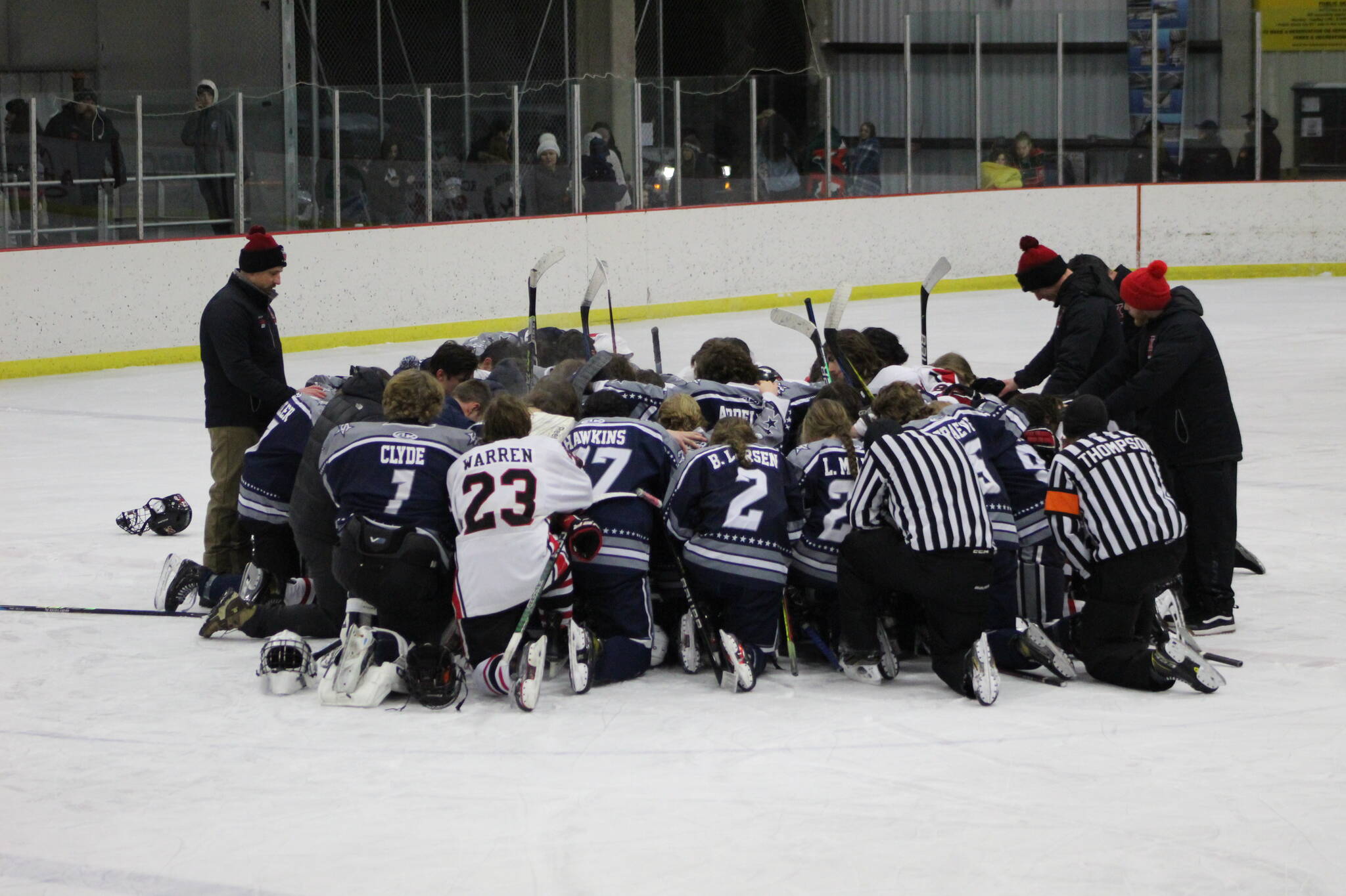 The SoHi and Kenai Central hockey teams meet at center ice to pray for the Clyde family after the game on Thursday, Dec. 16, 2022, at the Kenai Multi-Purpose Facility in Kenai, Alaska. Tanner Clyde, a SoHi goalie, lost his father to a fatal car collision earlier this week. (Photo courtesy Rylie Thompson)