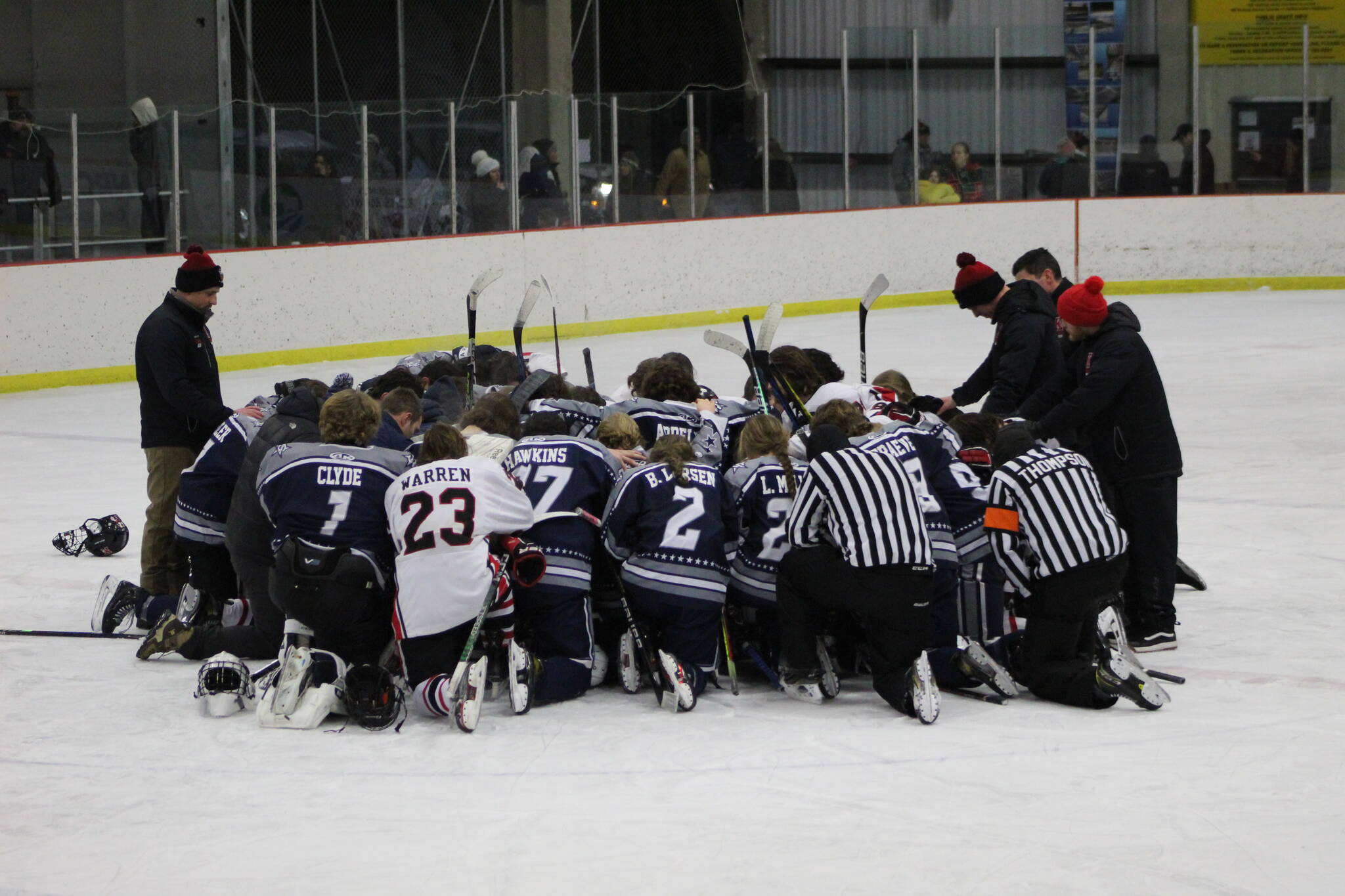 The SoHi and Kenai Central hockey teams meet at center ice to pray for the Clyde family after the game on Thursday, Dec. 16, 2022 at the Kenai Multi-Purpose Facility in Kenai, Alaska. Tanner Clyde, a SoHi goalie, lost his father to a fatal car collision earlier this week. (Photo courtesy Rylie Thompson)