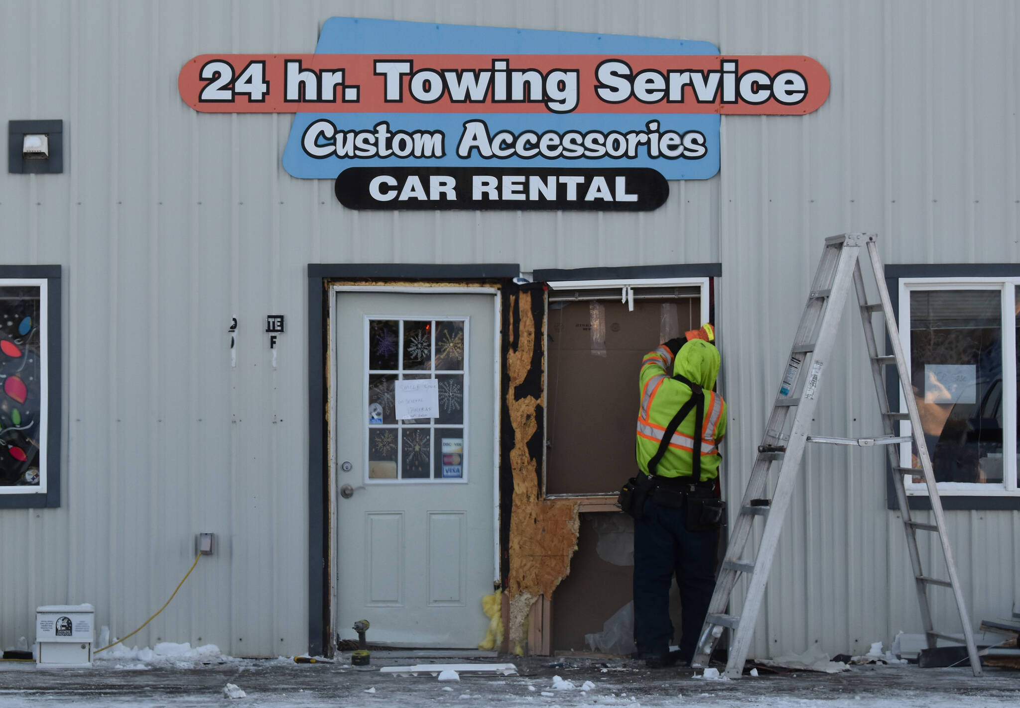 The front facade of Outlaw Body & Paint on Kalifornsky Beach Road undergoes repairs in Soldotna, Alaska, on Monday, Dec. 19, 2022. The building was hit by a car on Saturday night. (Jake Dye/Peninsula Clarion)