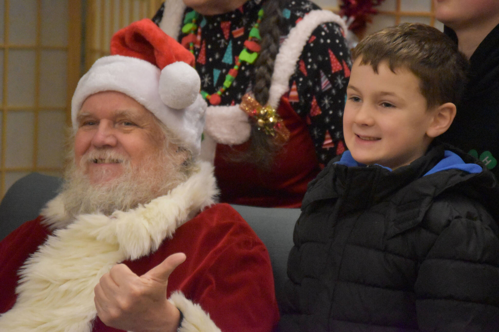 Ken Aaron, in the guise of Santa, smiles for a photo with a group of kids during Breakfast with Santa at the Kenai Senior Center in Kenai, Alaska, on Monday, Dec. 19, 2022. (Jake Dye/Peninsula Clarion)