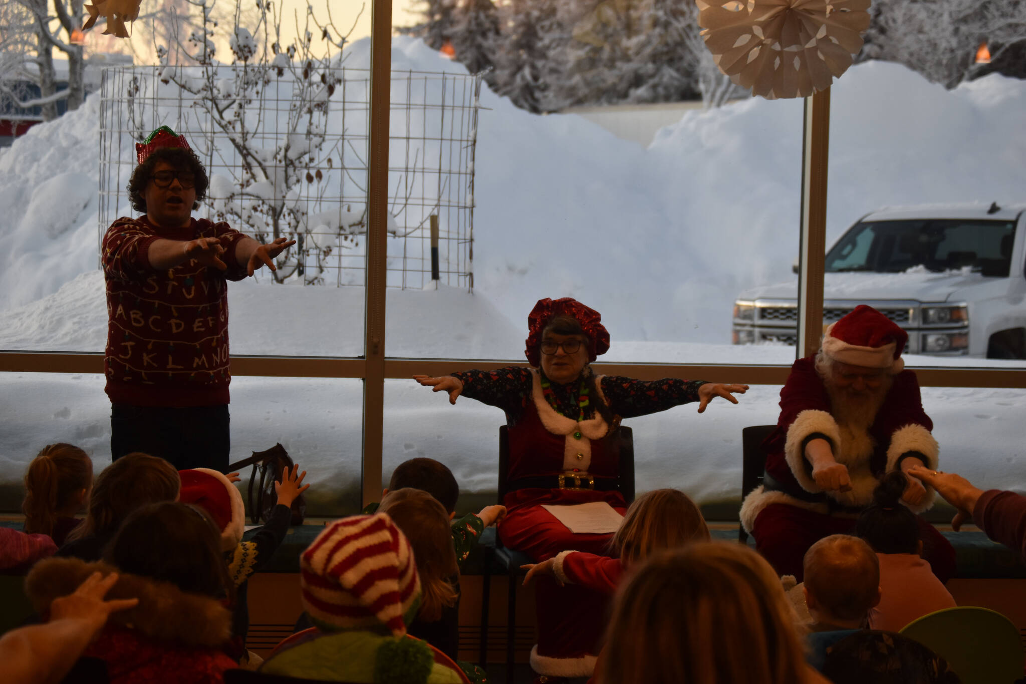Mrs. Claus (Kit Hill) and Santa (Ken Aaron) stretch their arms as they participate in a song during Story Time with Mrs. Claus at the Kenai Community Library in Kenai, Alaska, on Monday, Dec. 19, 2022. (Jake Dye/Peninsula Clarion)
