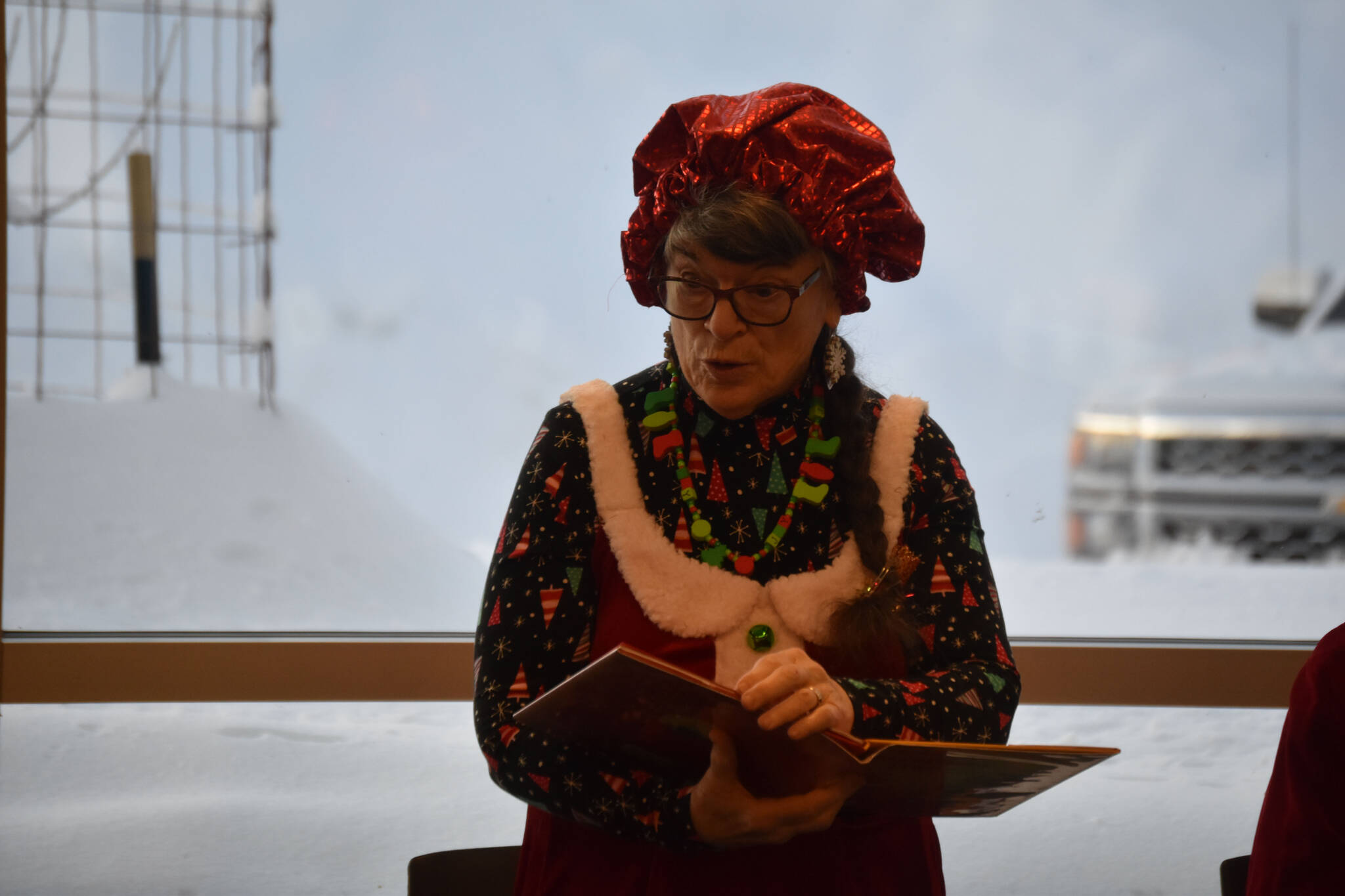 Mrs. Claus, played by Kit Hill, reads to the children during Story Time with Mrs. Claus at the Kenai Community Library in Kenai, Alaska, on Monday, Dec. 19, 2022. (Jake Dye/Peninsula Clarion)
