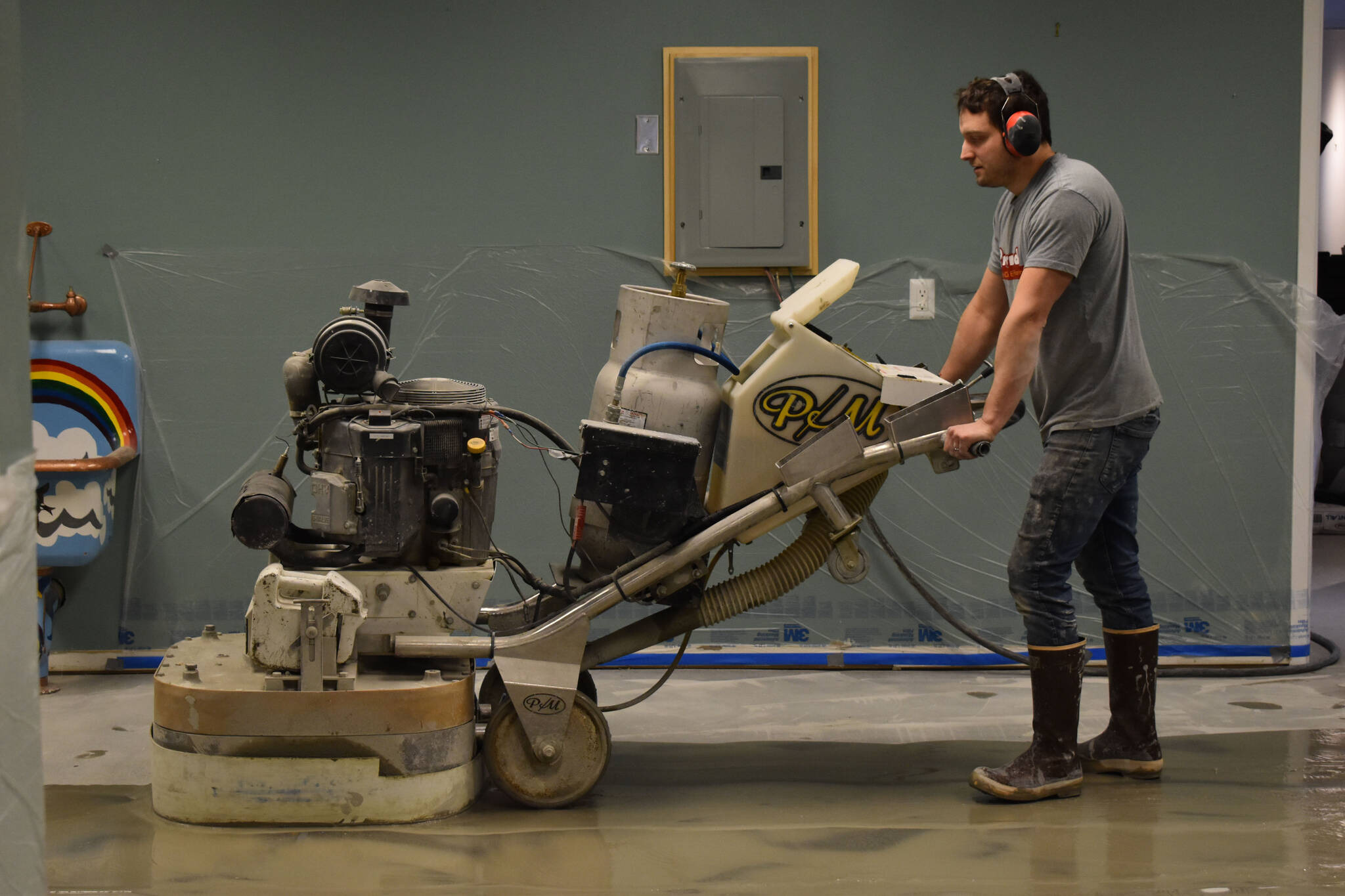 Jon Boehmler grinds the floors at the Kenai Art Center in Kenai, Alaska, as part of a flooring renovation on Wednesday, Dec. 28, 2022. (Jake Dye/Peninsula Clarion)