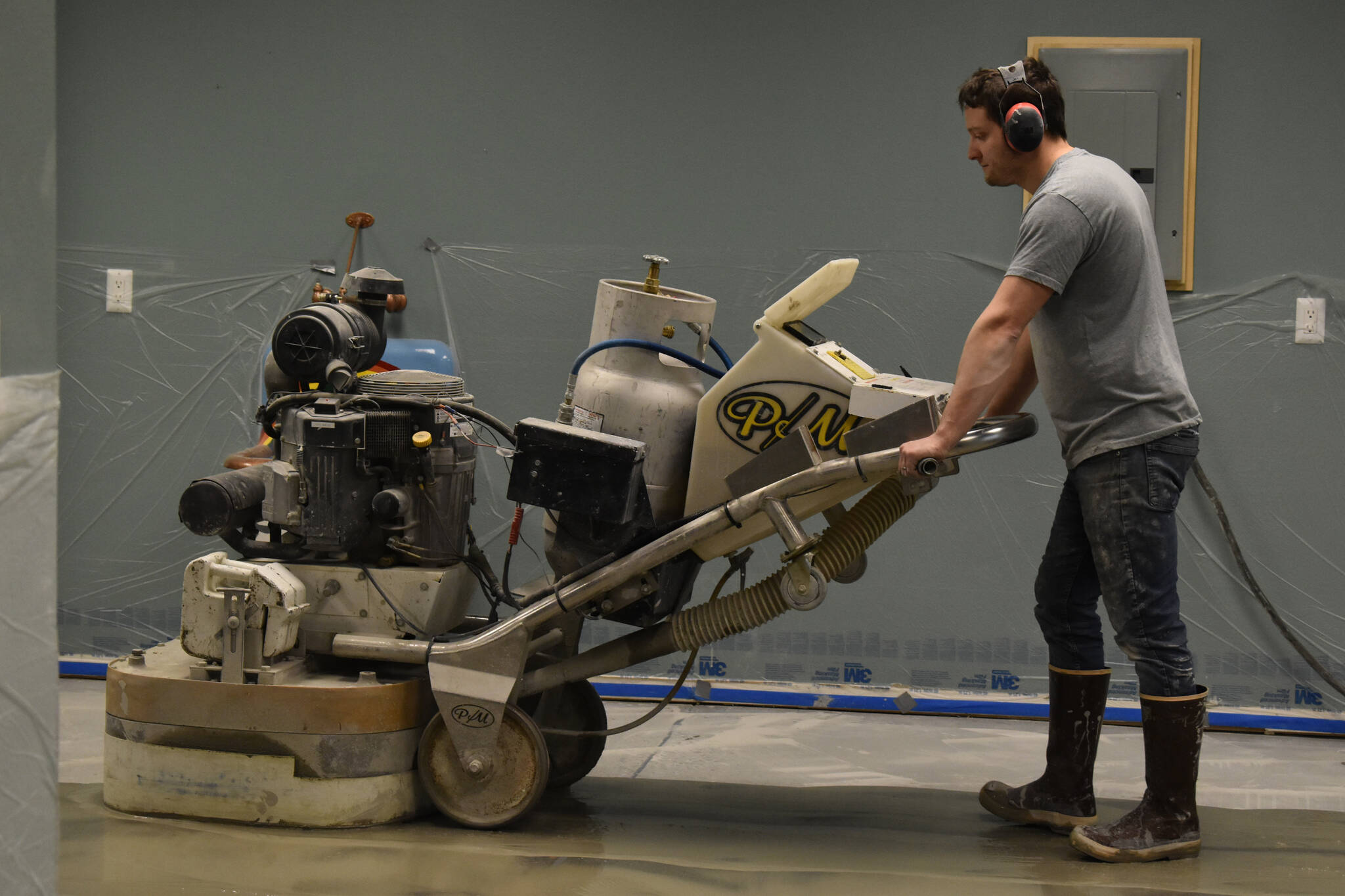 Jon Boehmler grinds the floors at the Kenai Art Center in Kenai, Alaska, as part of a flooring renovation on Wednesday, Dec. 28, 2022. (Jake Dye/Peninsula Clarion)
